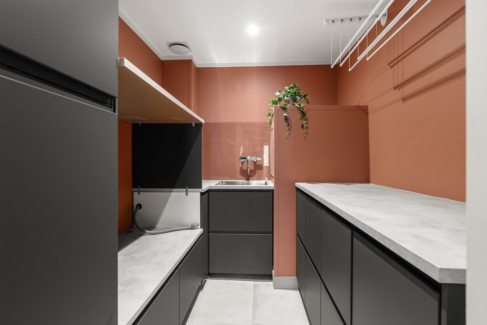 Separat vaskerom med nedfelt skyllekar i benkeplate og laminert innredning med glatte fronter. Det er røropplegg til vaskemaskin Galleribilde