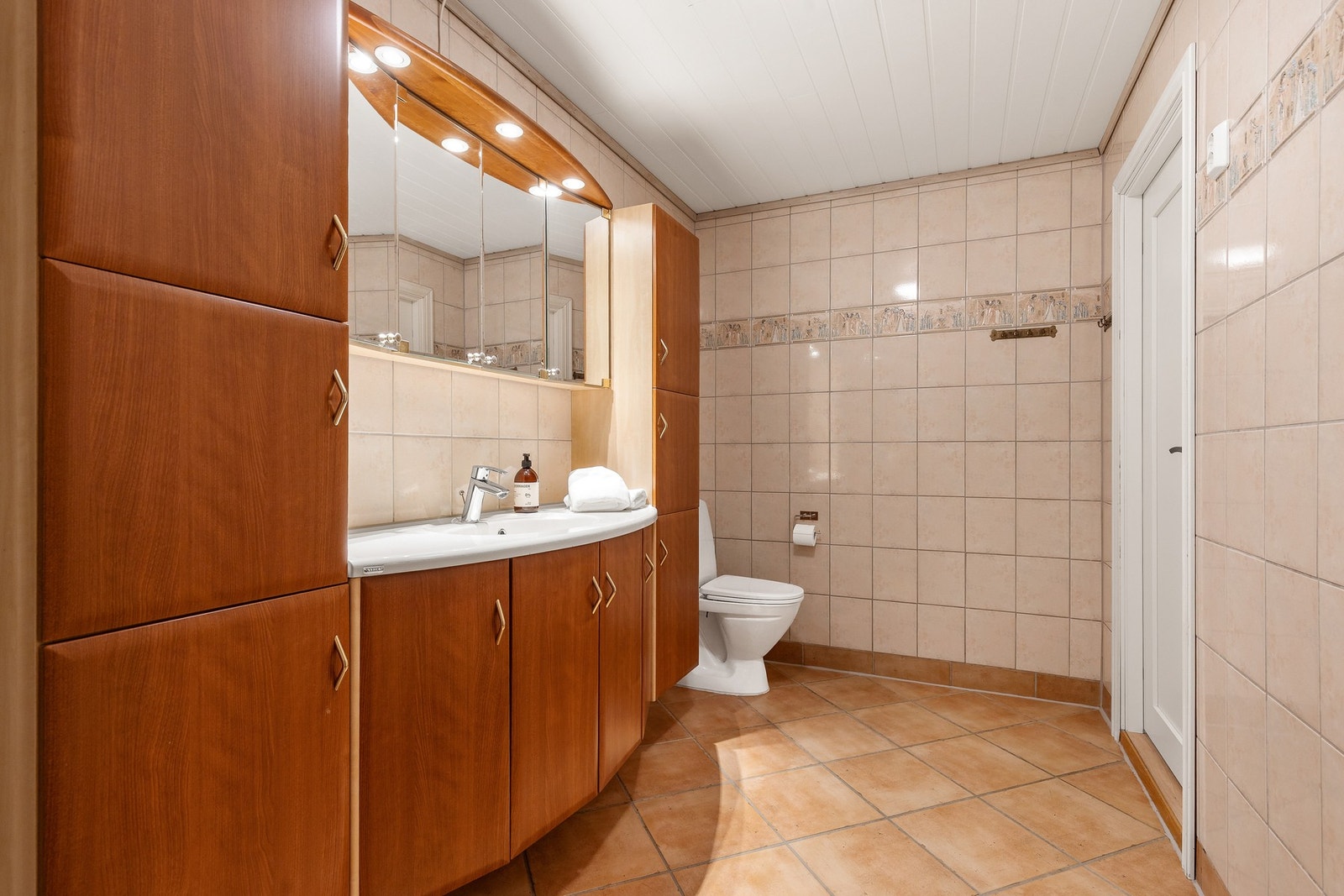 Rommet er innredet med baderomsinnredning med nedfelt servant, gulvstående toalett og dusjkabinett Galleribilde