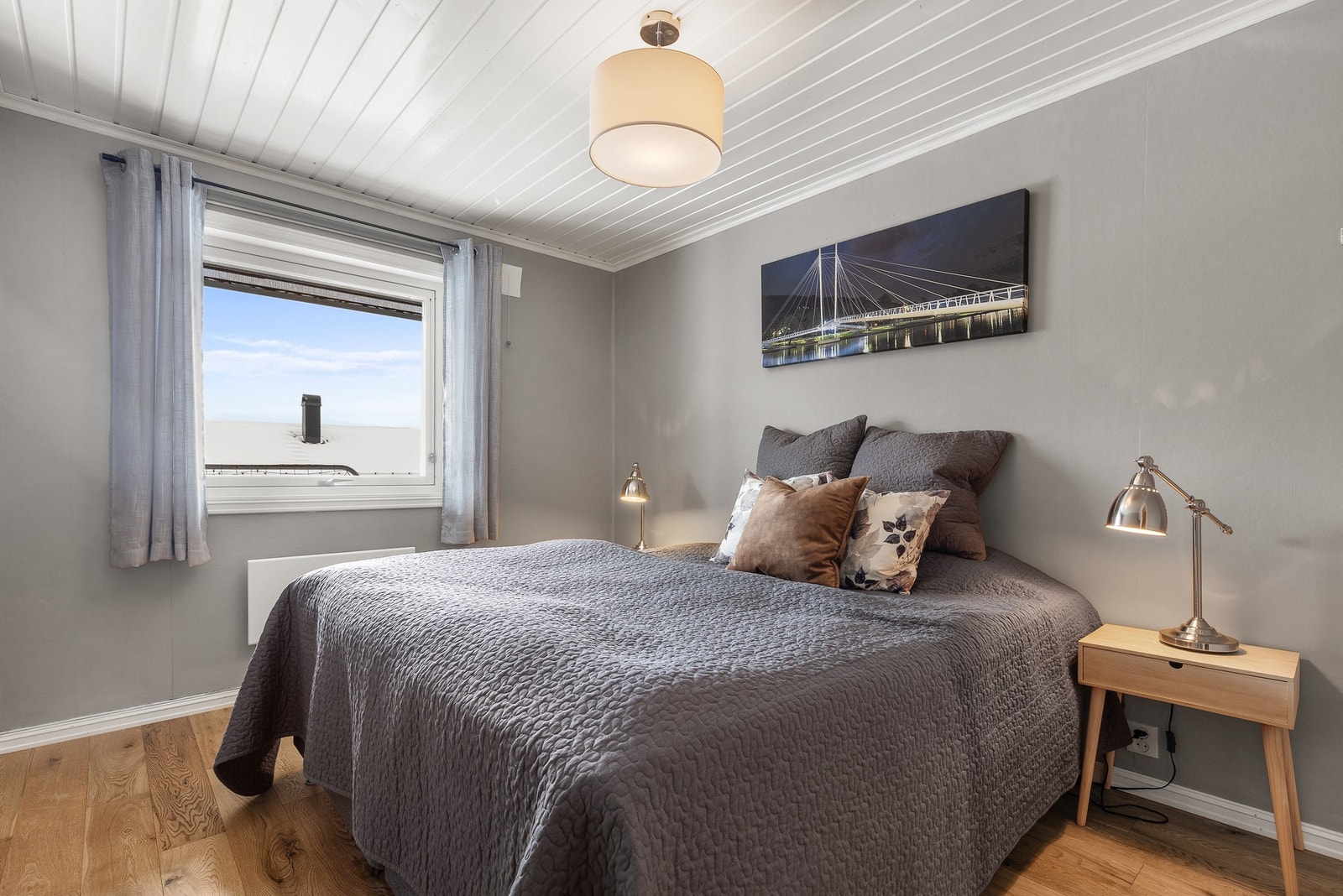 Romslig hovedsoverom med 1-stavs parkettgulv, malt tapet på vegger og panel i himling Galleribilde