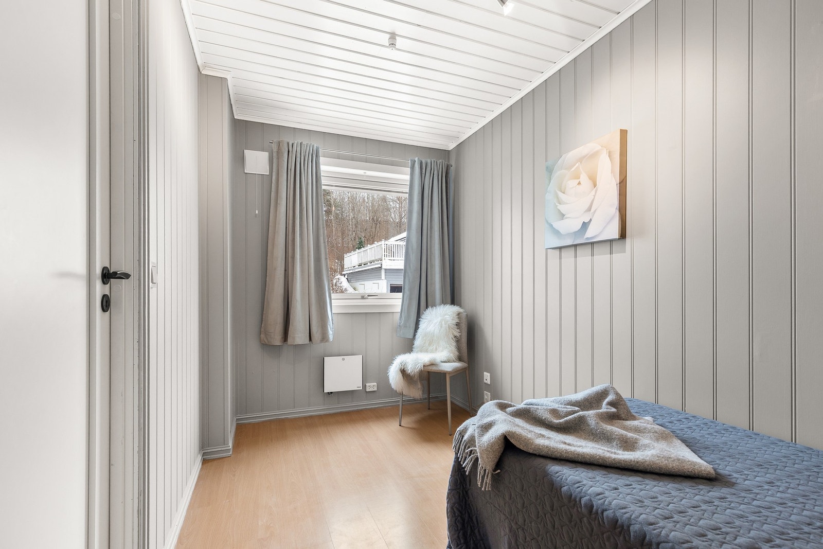 Soverom med laminat på gulv og panel på vegger og i himling Galleribilde