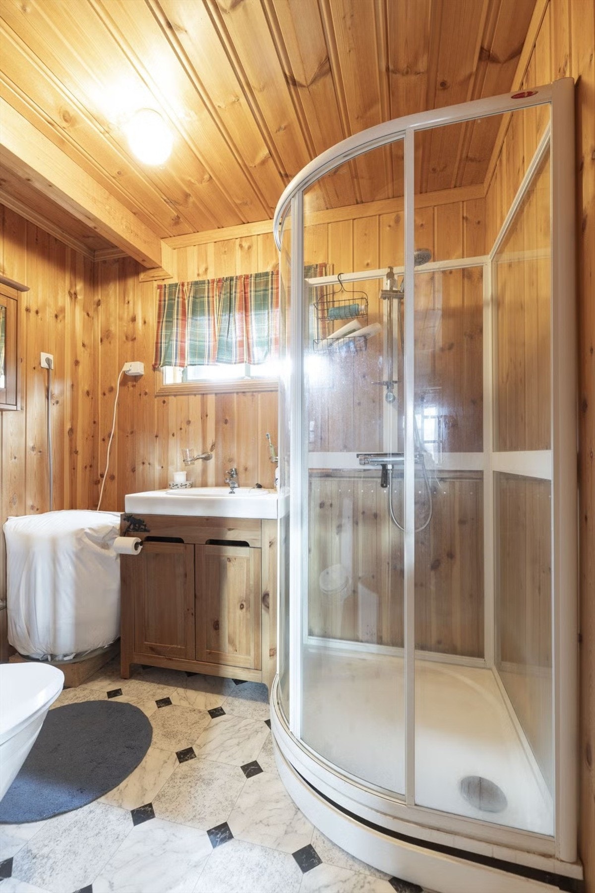 Gulvet har belegg, veggene er panelte, og vindu sørger for naturlig ventilasjon. Galleribilde