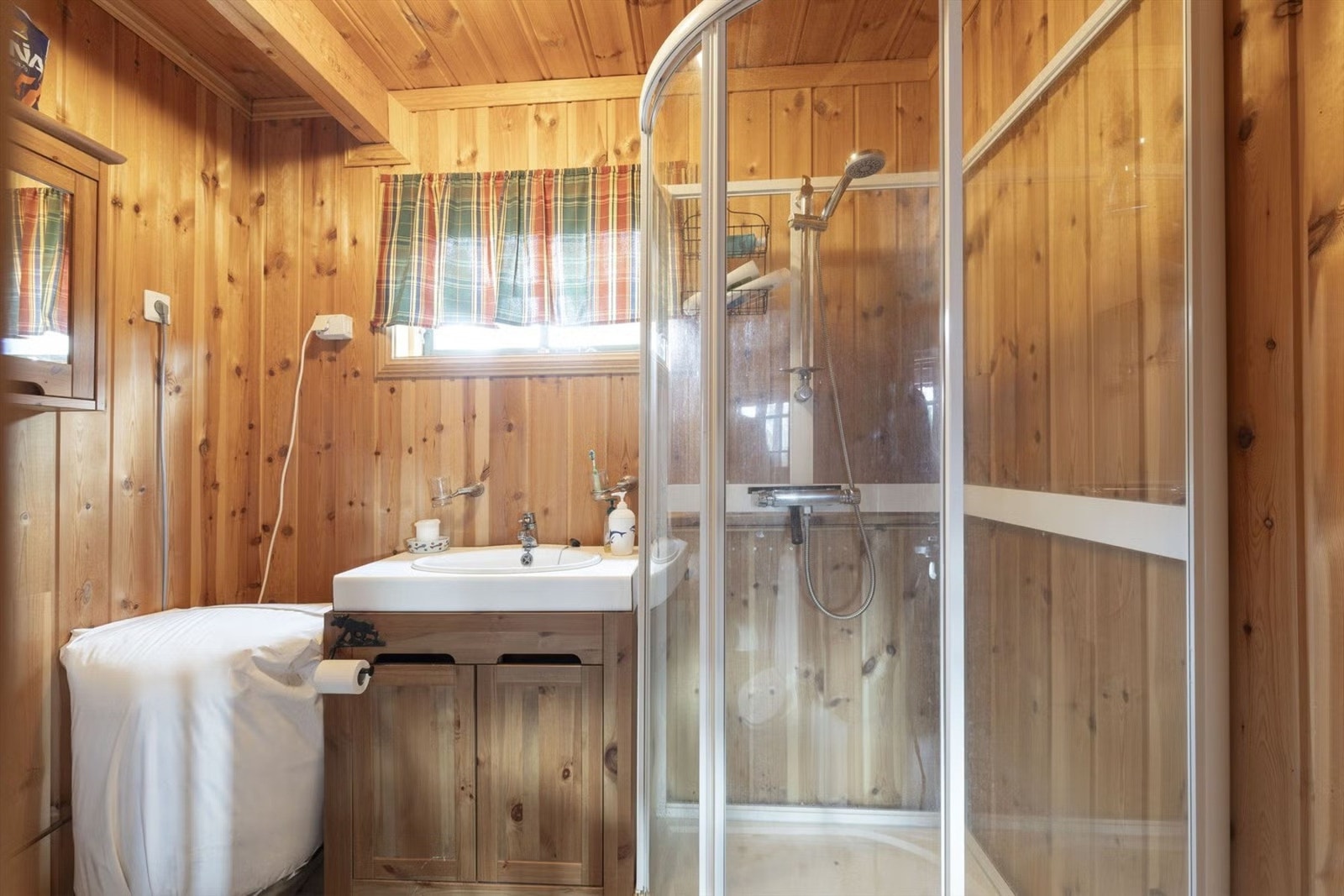 Badet er utstyrt med toalett, dusjkabinett og baderomsinnredning med heldekkende servant og speilskap. Galleribilde