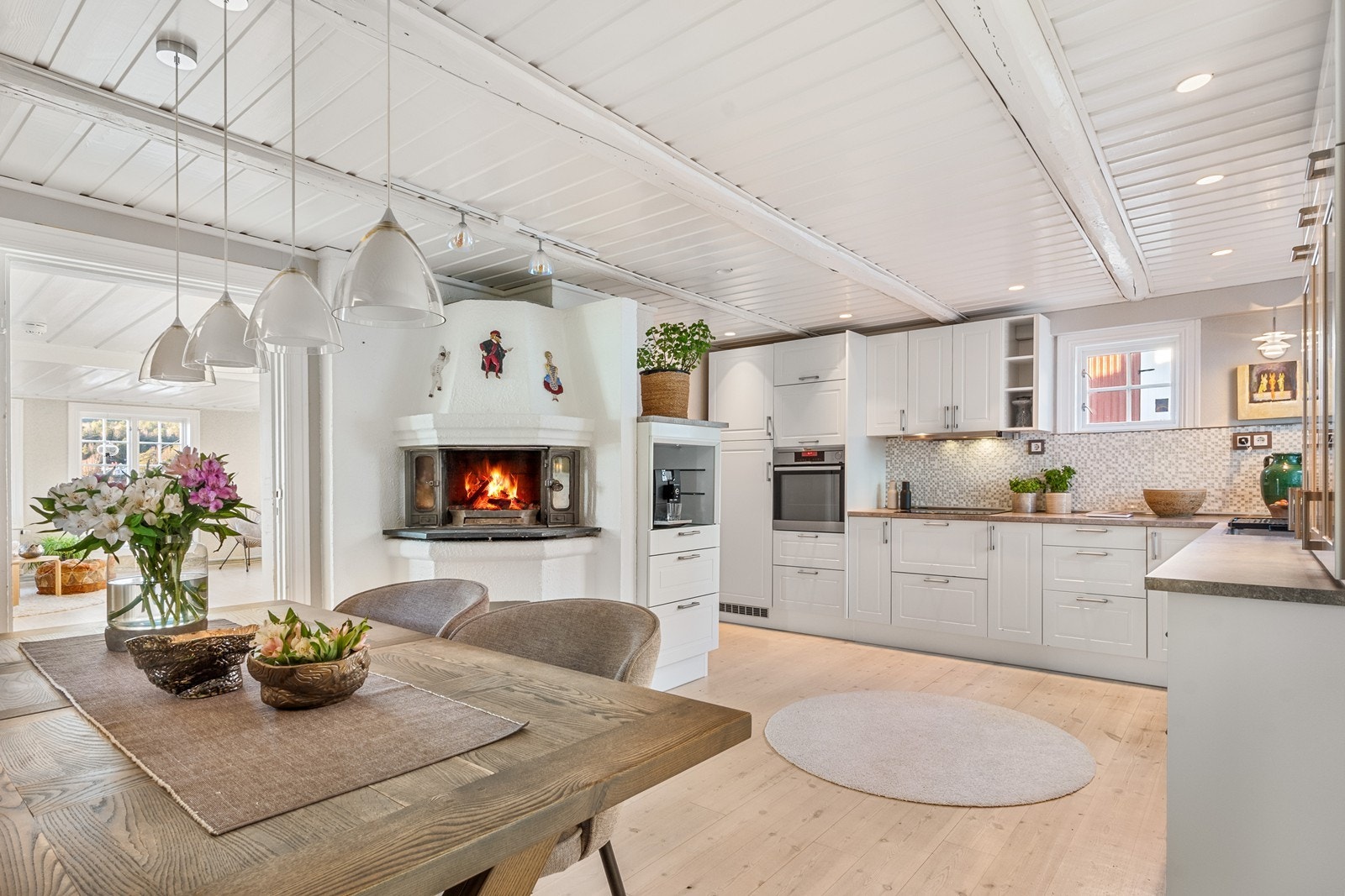 Midt i rommet er en murt peisinnsats vendt mot spisestue som gir mulighet for både varme og hygge. Galleribilde