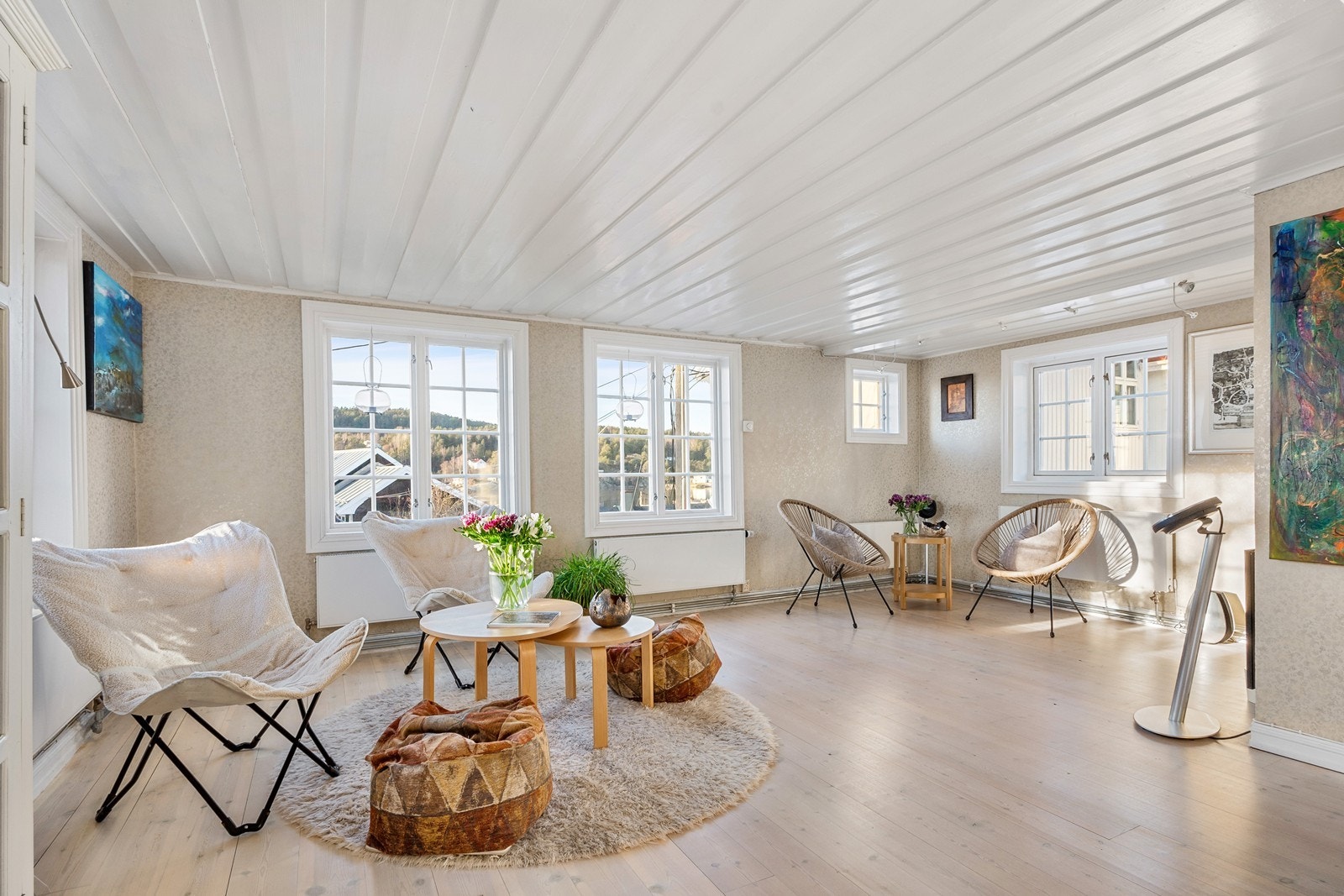 Her er det samme flotte tregulv som på kjøkken, hvitmalt paneltak og tapetserte vegger. Galleribilde