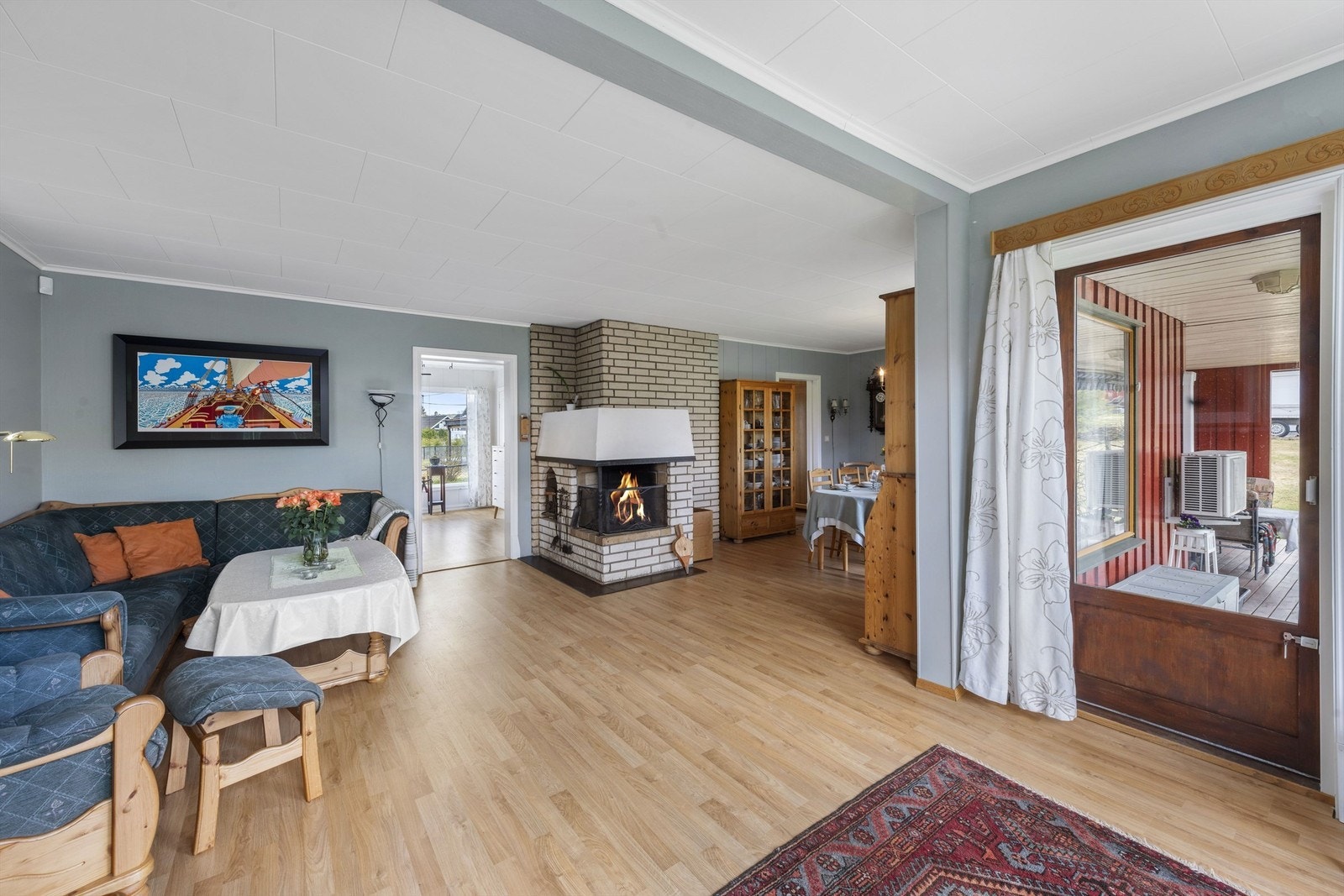 Romslig stue med peis og åpen løsning mot spisestue. Store vindusflater gir godt lysinnslipp. Galleribilde