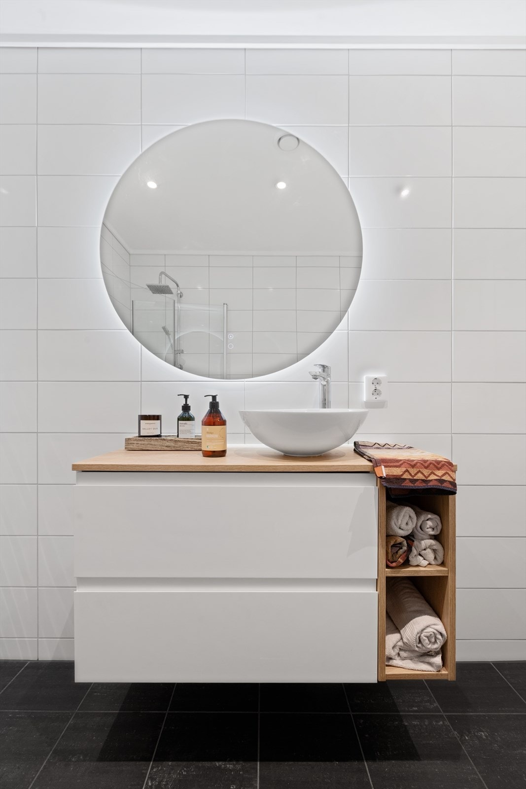 Moderne, hvit baderomsinnredning med benkeplate og bolleservant, og speil med integrert belysning. Galleribilde