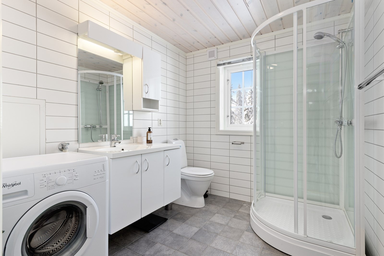 Badet er innredet med servantløsning med plass til diverse oppbevaring og speil. Videre er badet utstyrt med toalett og dusjkabinett. Rommet har opplegg for vaskemaskin. Galleribilde