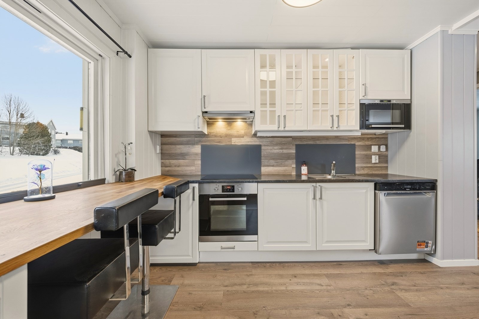 Kjøkkenet er utstyrt med integrerte hvitevarer som mikro, stekeovn, platetopp fra 2026, samt frittstående kjøleskap og oppvaskmaskin (2025) Galleribilde