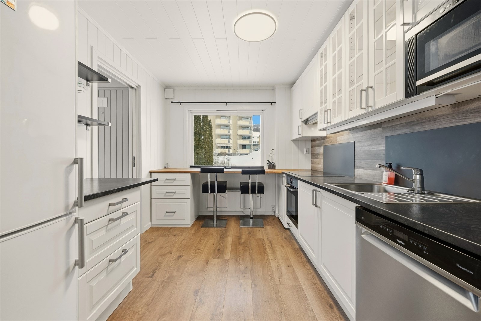 Pent og moderne kjøkken med profilerte fronter, veggplate fra 2025 og benkeplate i laminat og eik Galleribilde