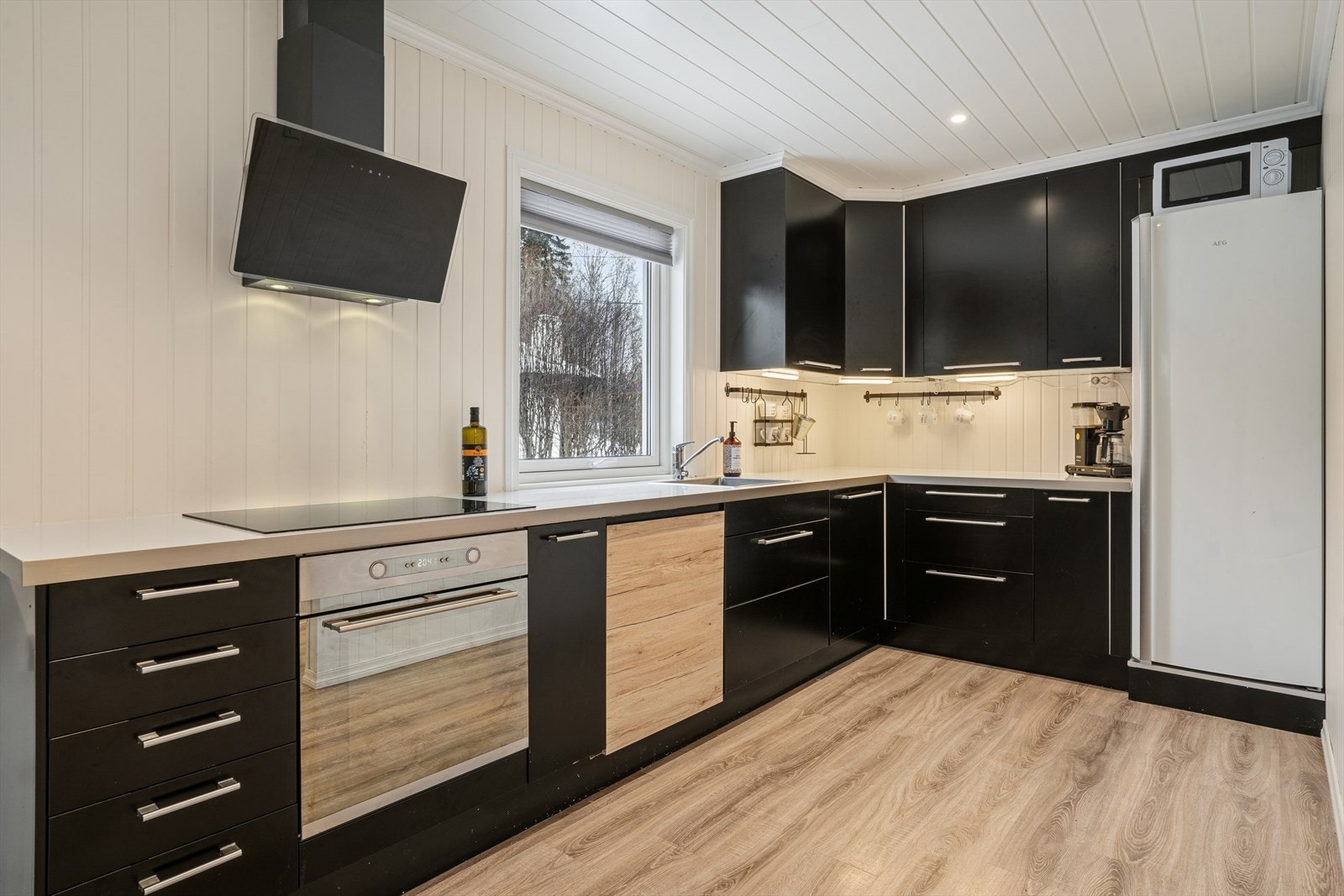 Kjøkkenet har en takhøy innredning fra 2010 med slette fronter og laminatbenkeplate. Galleribilde