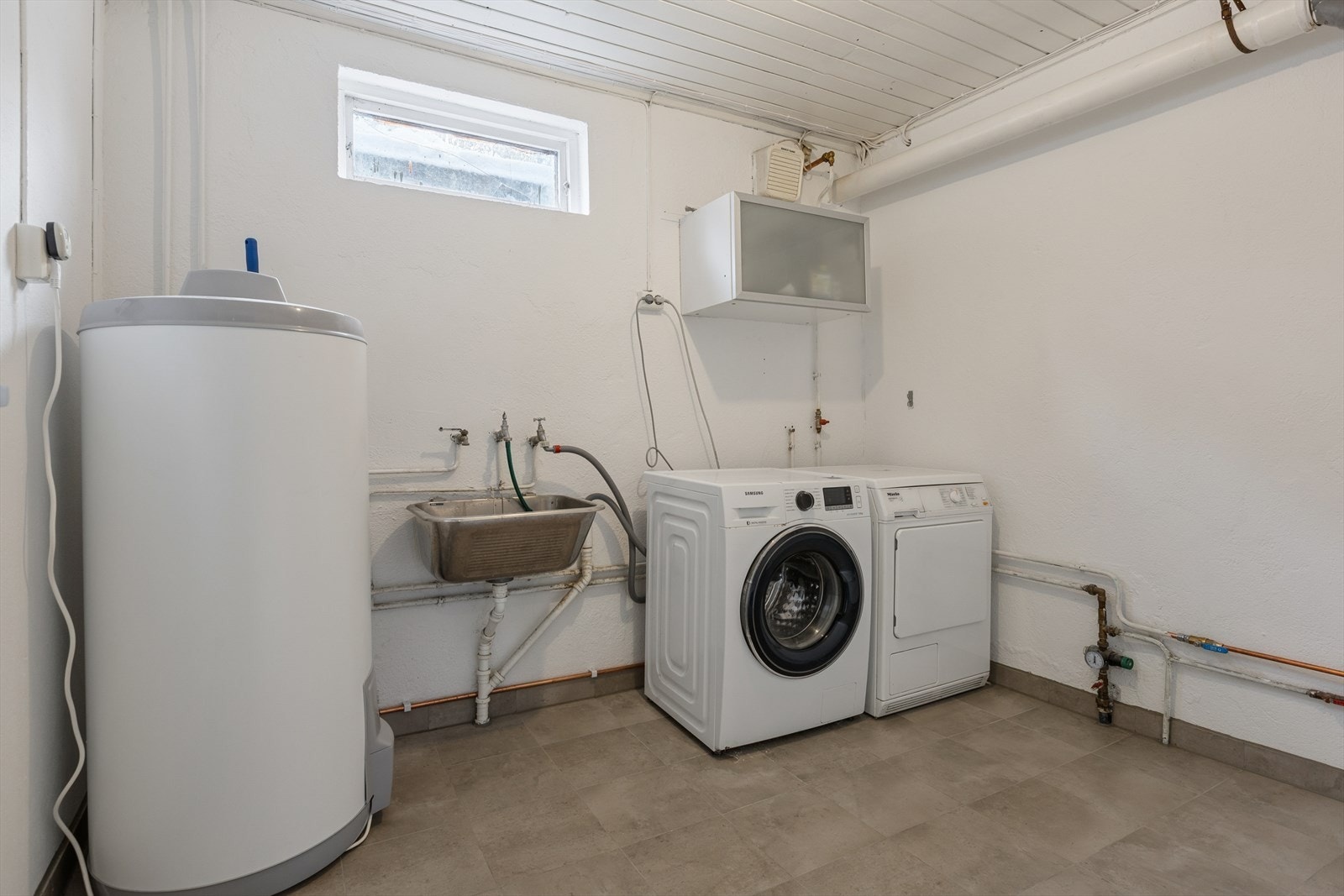 Her er det et praktisk vaskerom som har godt med oppbevaringsplass. Galleribilde