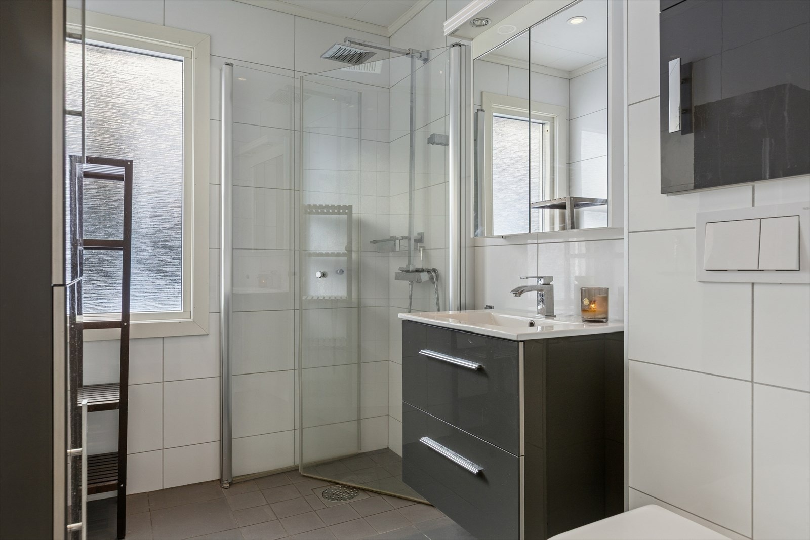 Flisbelagt bad i 1. etasje med varme i gulvet. Oppbevaring i servant med underskap og speilskap. Galleribilde