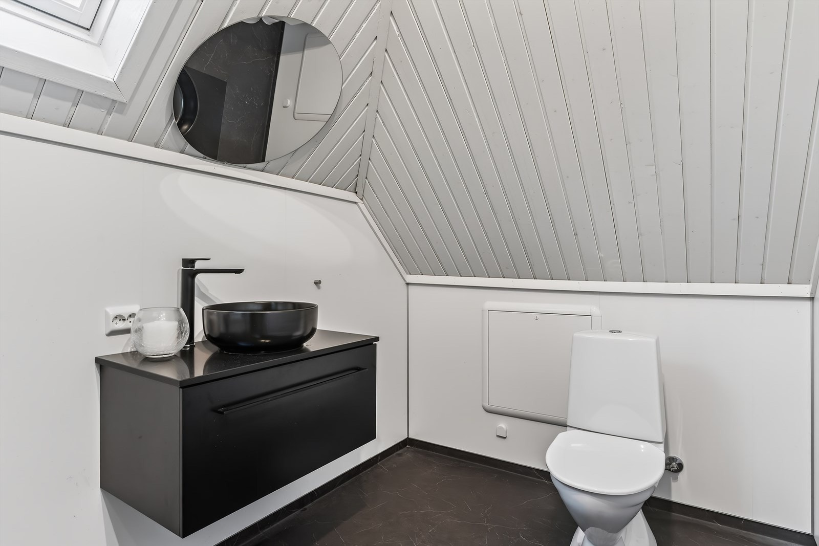 Rom innredet som baderom med stilig baderomsmøblement i sort. Galleribilde