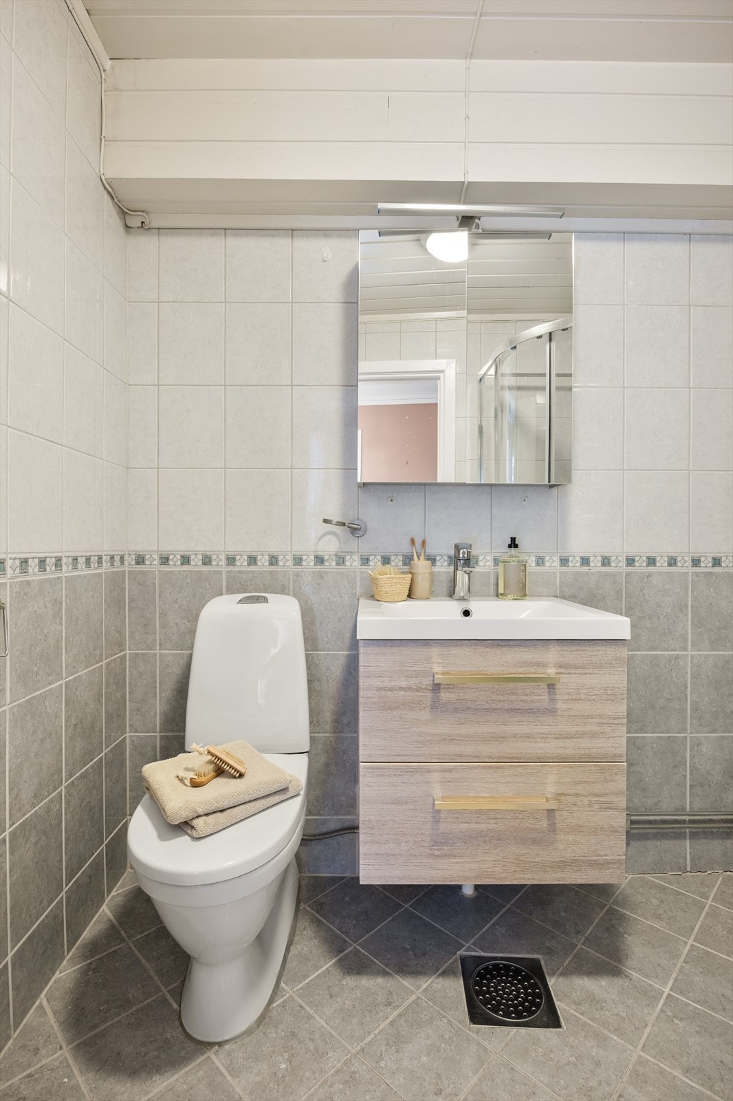 Badet har flislagte overflater på gulv og vegger, og innredning med glatte fronter. Galleribilde