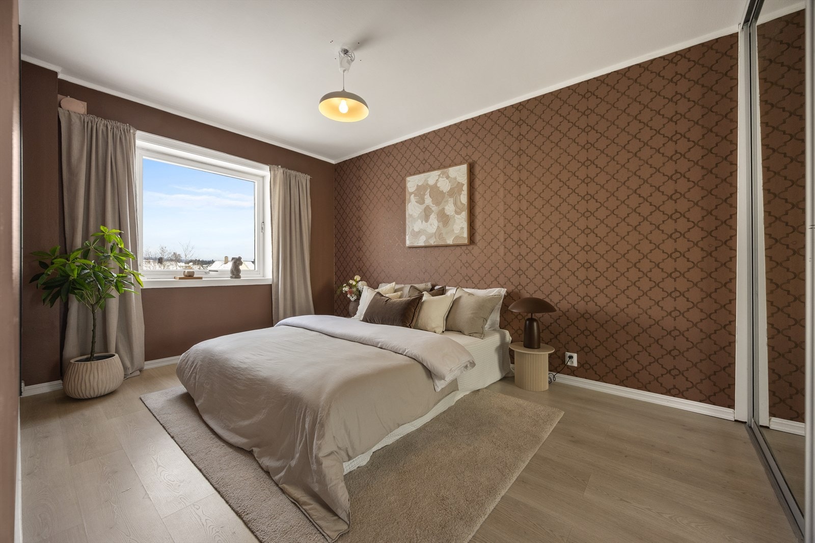 Rommet har laminatgulv og en fondvegg med tapet. Galleribilde