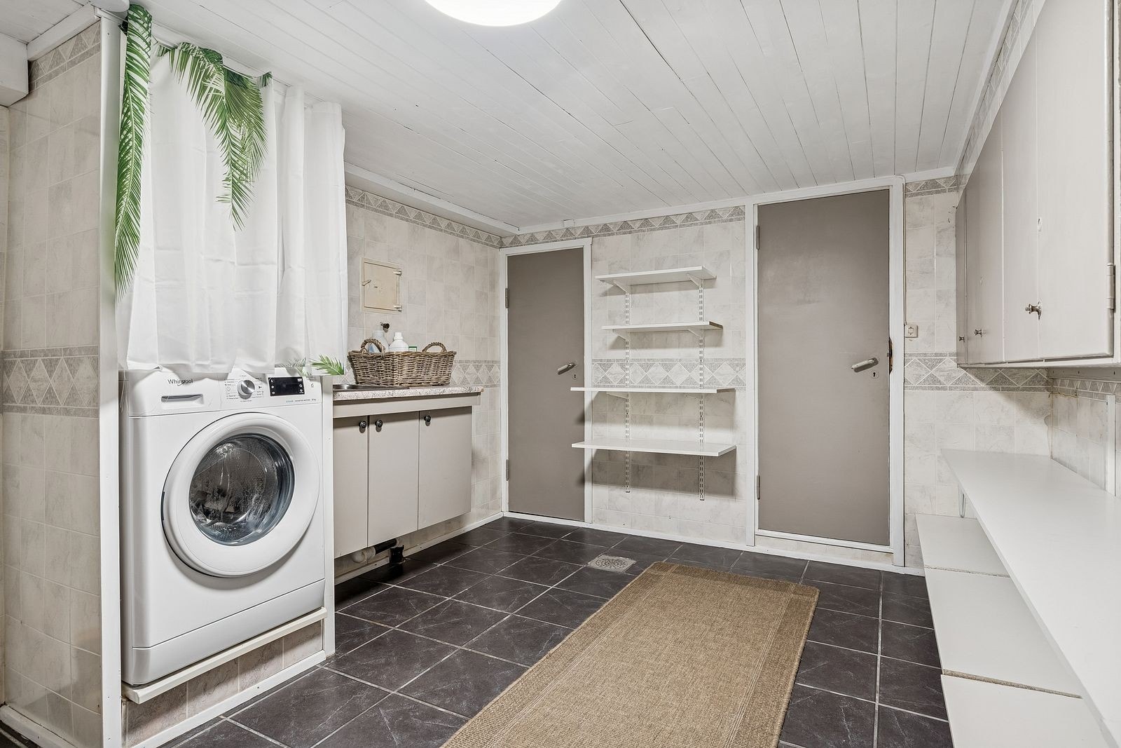Vaskerommet i kjelleren har opplegg for vaskemaskin, skyllekum i innredning, diverse skap- og hylleplass, samt adkomst til to boder. Galleribilde