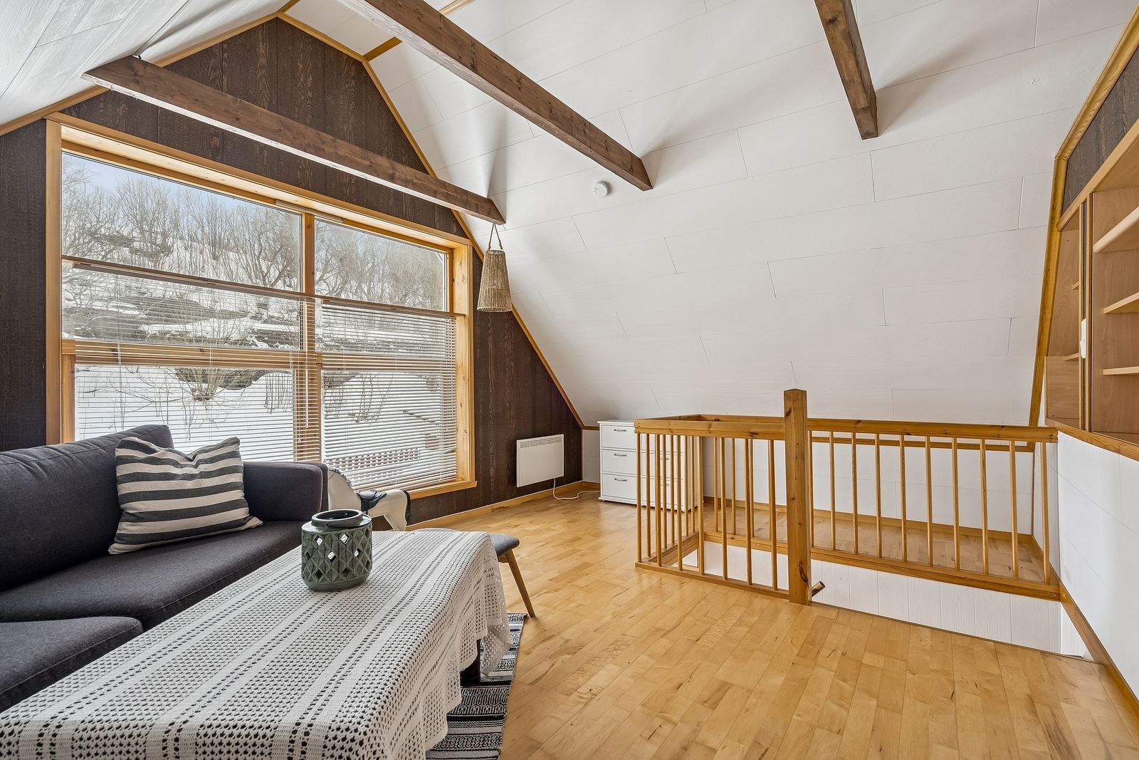 Hvem vil ikke ha en loftstue til ungdommen, tv-stua eller for å kunne trekke seg tilbake med en god bok og en kaffekopp. Hemsen er etablert over de plassbygde hyllene som sees i kanten av bildet. Det er store vinduer som gir godt med lys inn i rommet. Galleribilde