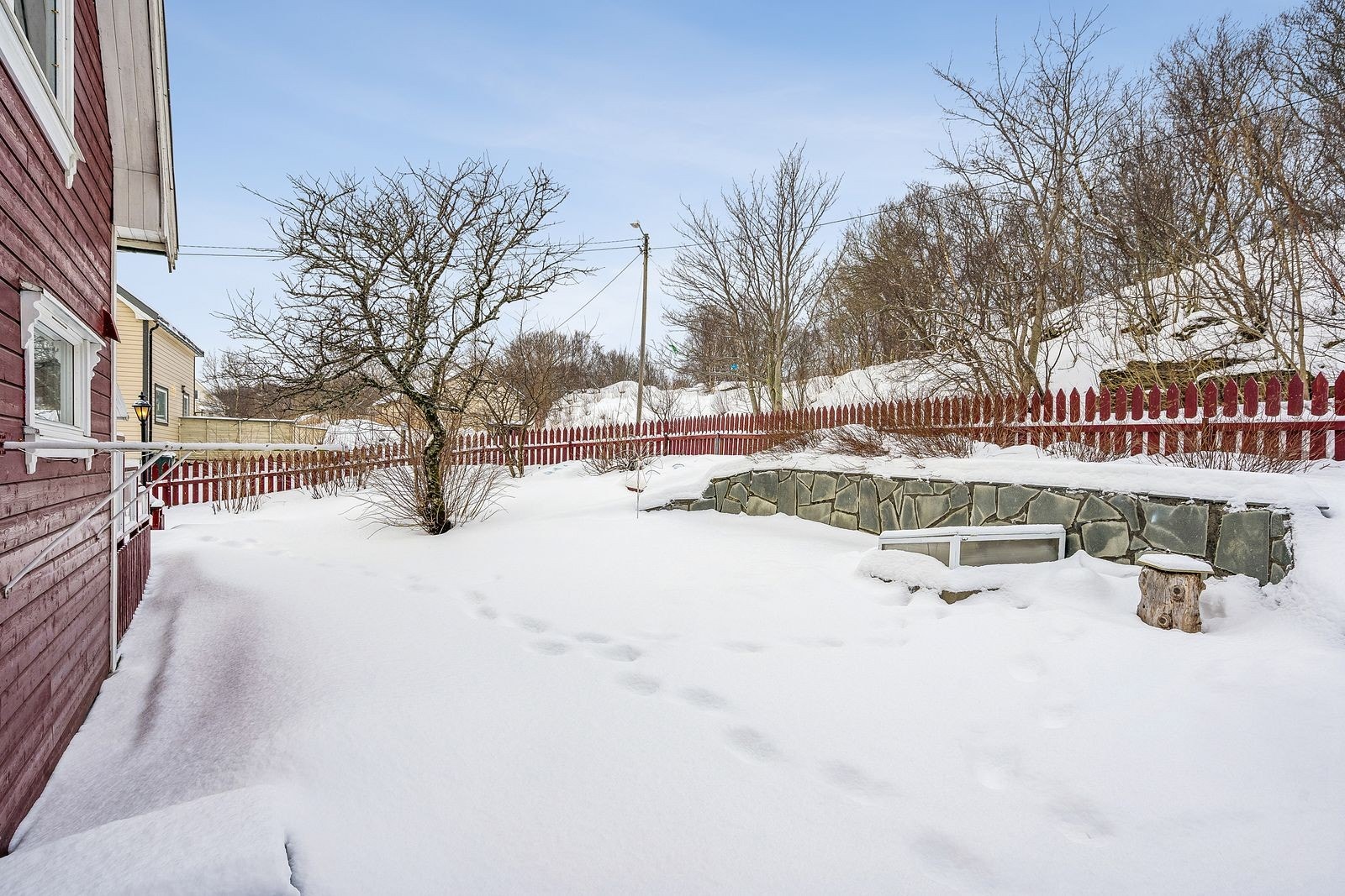 Forstøtningsmuren har steinheller som er dekorativ mot en oppgruset sitteplass i hagen. Foto: Lene Blomsøy. Galleribilde