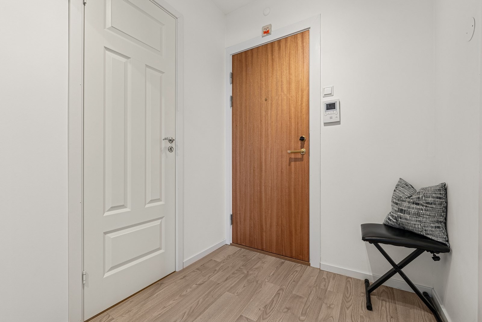 Entréen er lys og innbydende med malte overflater og laminatgulv. Galleribilde