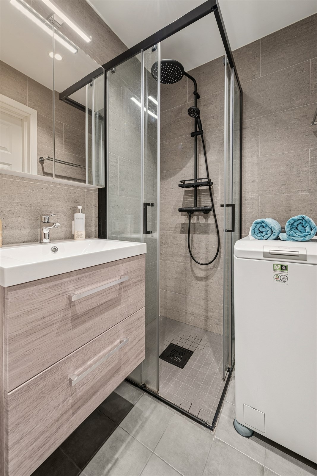 Her er det dusjhjørne med innfellbare vegger og praktisk opplegg for vaskemaskin. Galleribilde