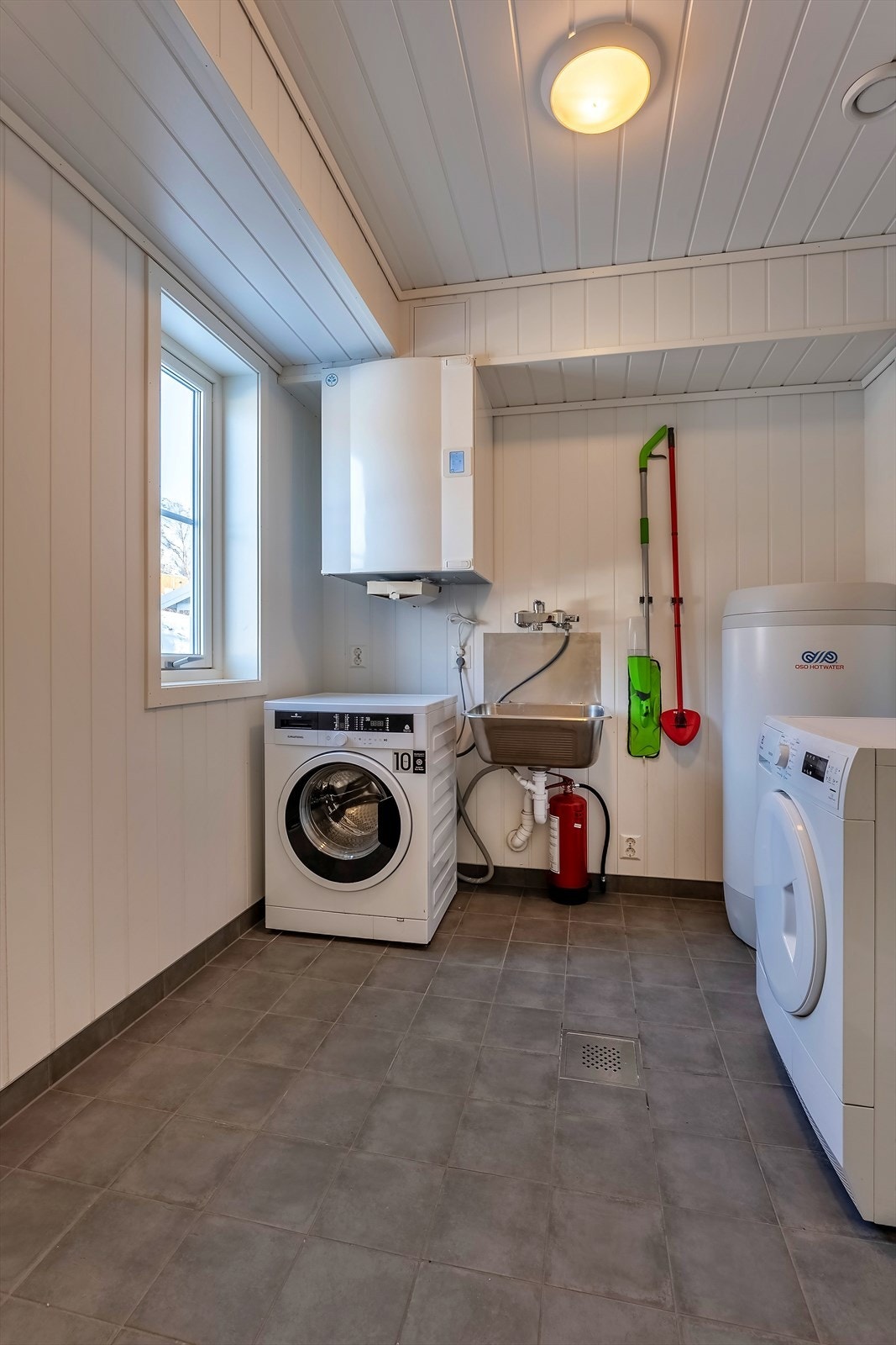 Praktisk vaskerom i tilknytning til inngangspartiet - Rommet huser også mye av boligens tekniske utstyr Galleribilde