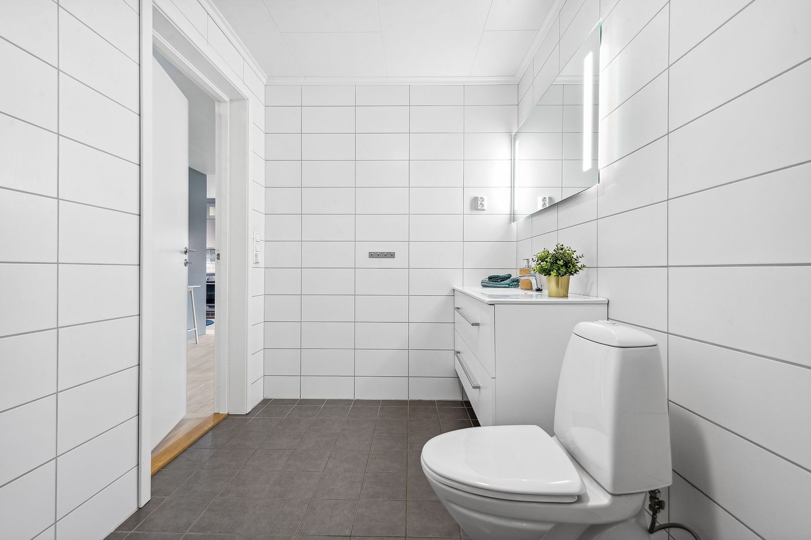 Pent og lyst baderom med flislagte overflater og varmekabler i gulv. Galleribilde