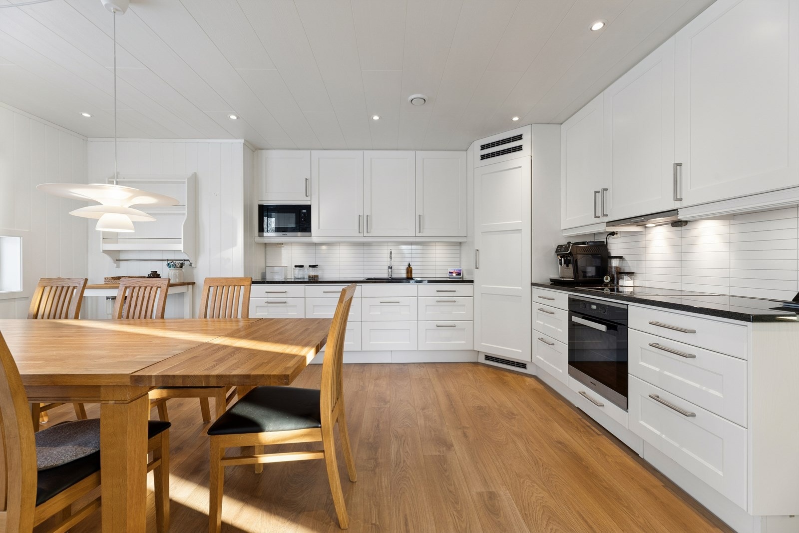 Lyst og tidløst kjøkken med alt en måtte trenge av skap-, skuff- og benkeplass. Benkeplate i solid granitt. Galleribilde