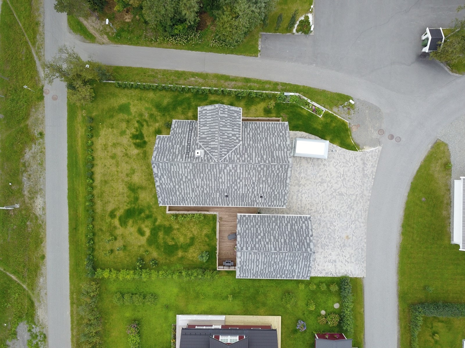 Dronebilde viser pent opparbeidede uteområder med bla. belegningsstein i innkjørsel (privatfoto fra 2018) Galleribilde