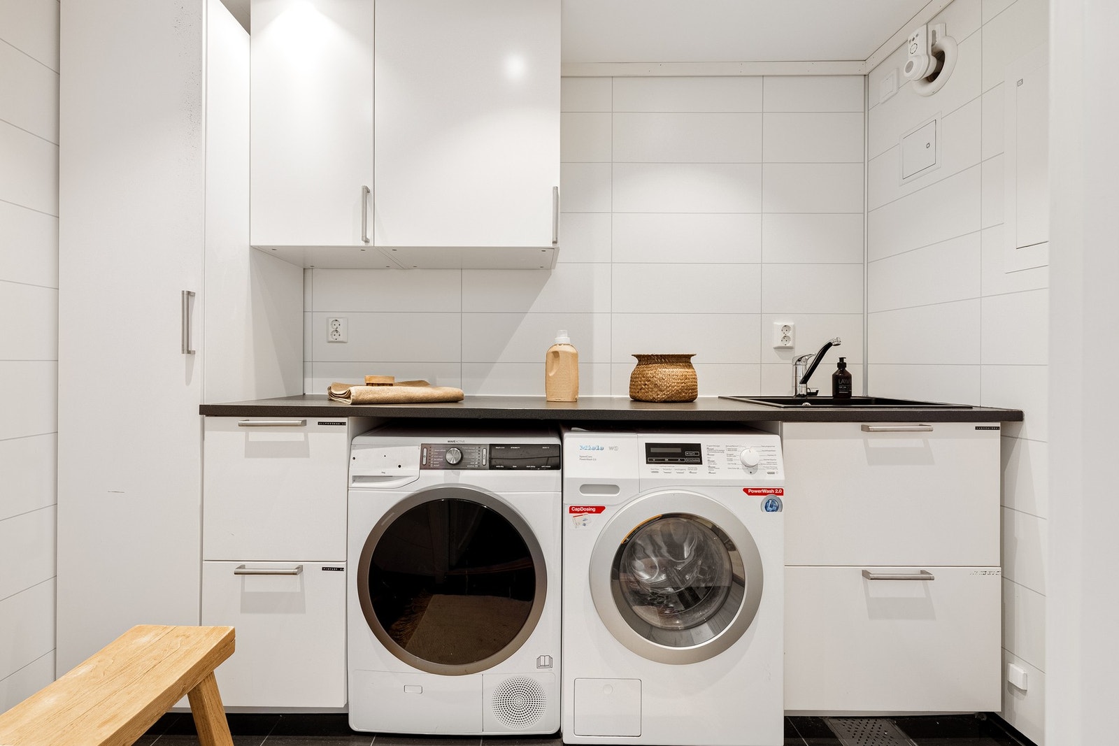 Vaskerommet er innredet med kjøkkeninnredning med opplegg for vaskemaskin og tørketrommel integrert i innredning. Galleribilde
