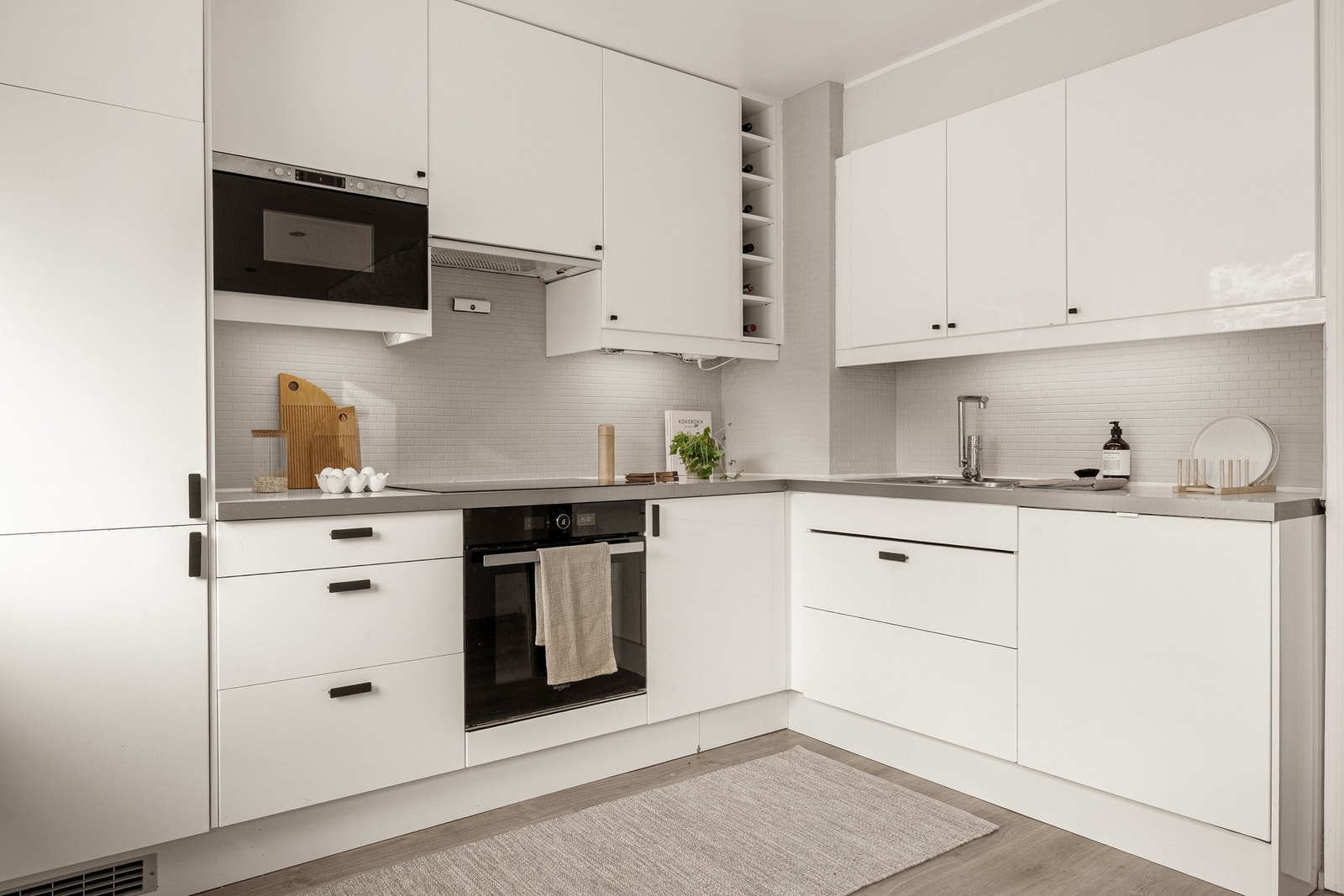 Kjøkkeninnredning med slette fronter og laminat benkeplate med nedfelt vask av stål. Galleribilde