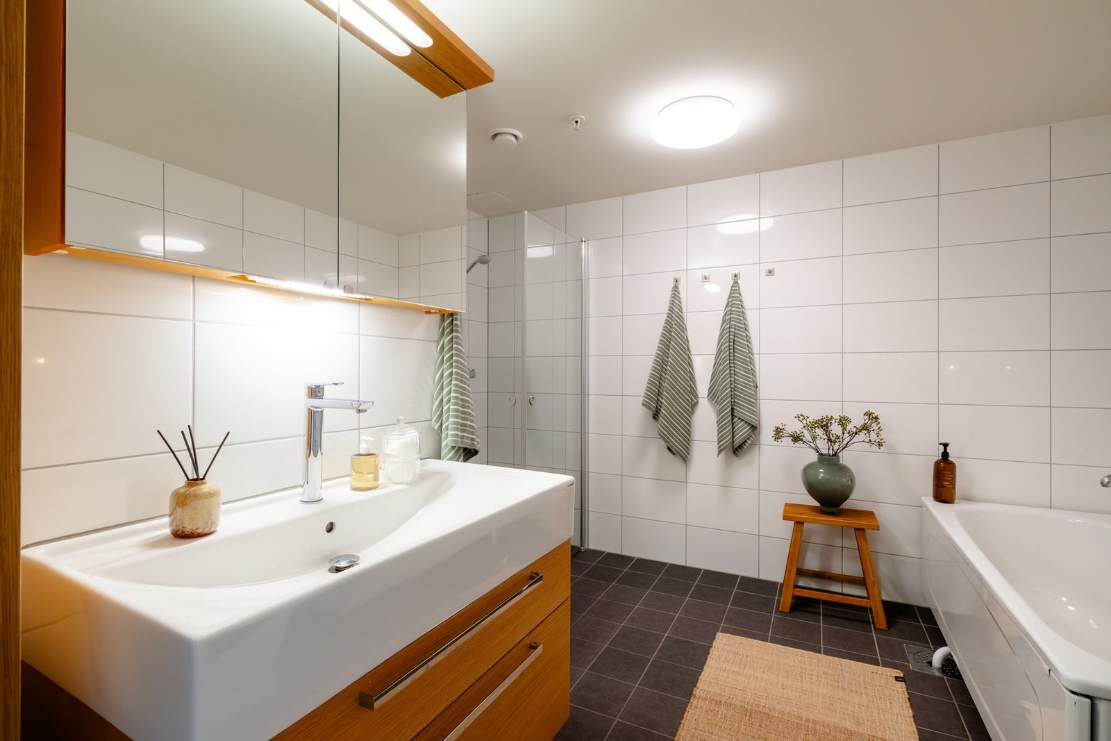 Lyst og romslig bad med flislagte flater og varmekabler i gulv. Galleribilde