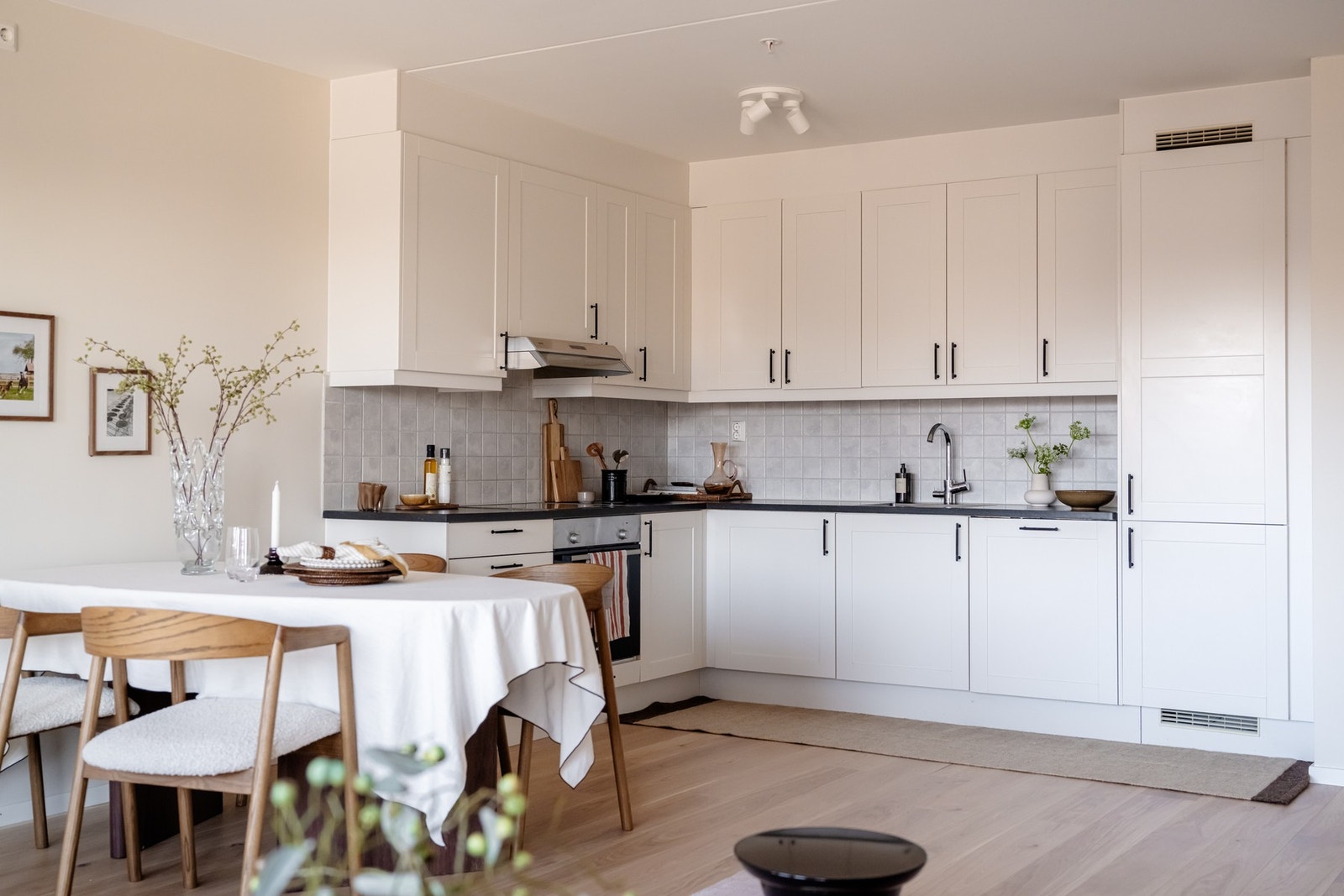 Glatte fronter kombinert med mørk benkeplate og sorte detaljer gjør kjøkkenet moderne og sofistikert. Galleribilde