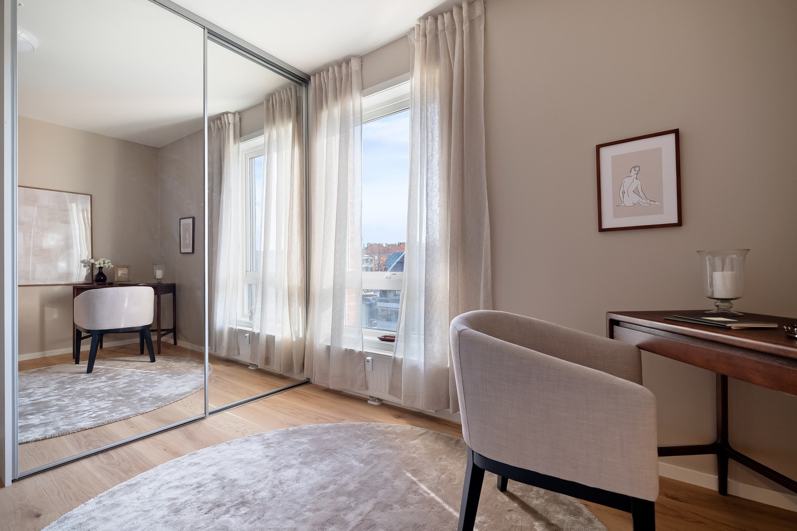 Garderobeskap med speilfronter gir praktisk oppbevaring og bidrar til å forsterke romfølelsen visuelt. Galleribilde