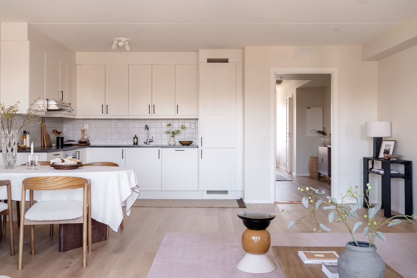 Glassfelt mot entréen lar dagslyset vandre gjennom boligen og forsterker den åpne planløsningen. Galleribilde