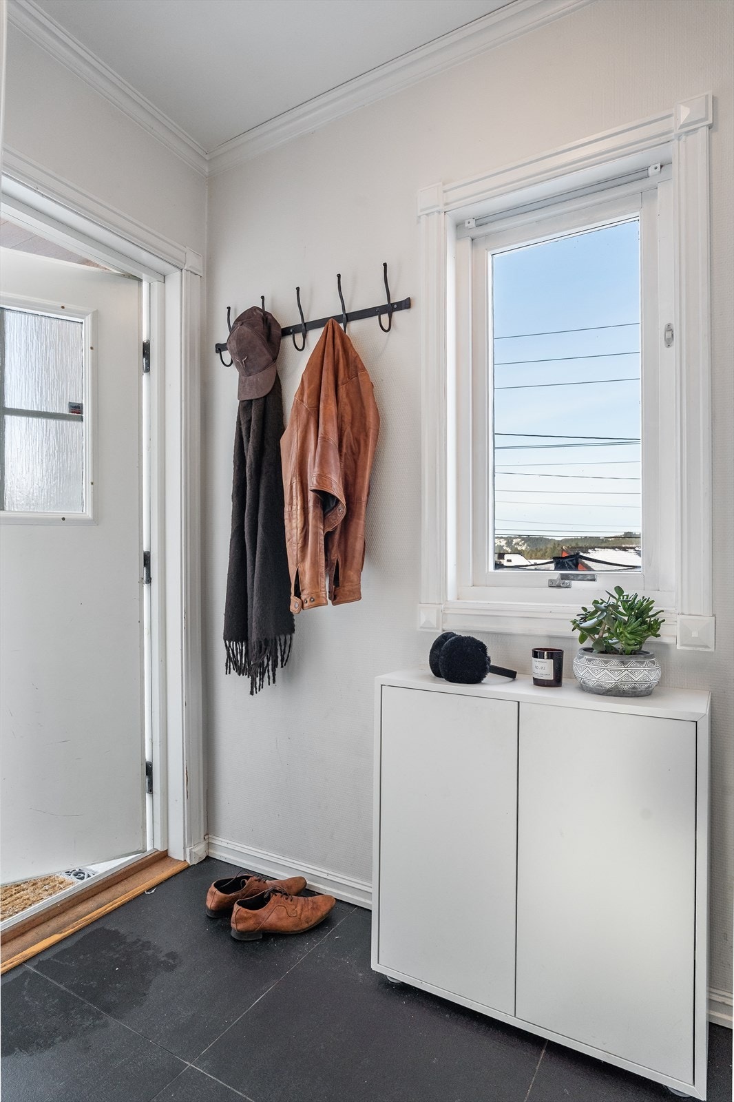 Fliser i entréen gjør rommet både funksjonelt og lettstelt. Galleribilde