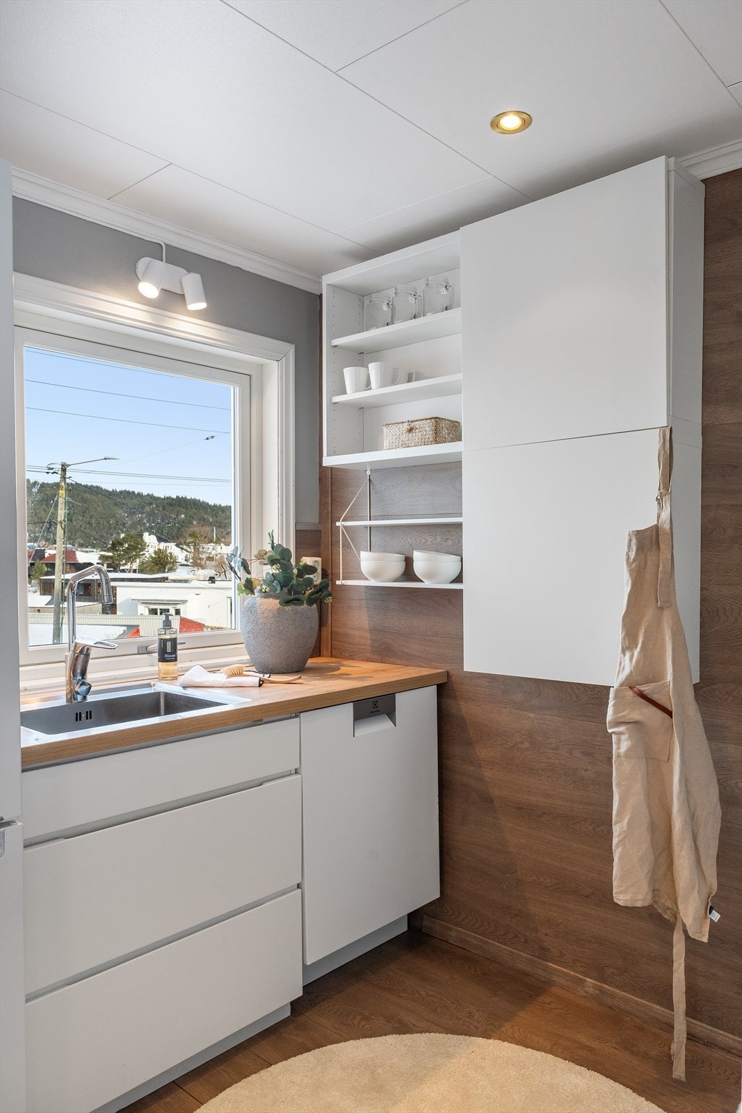 Gjennomført materialvalg med laminatkledd vegg og lyse oppbevaringsløsninger. Galleribilde