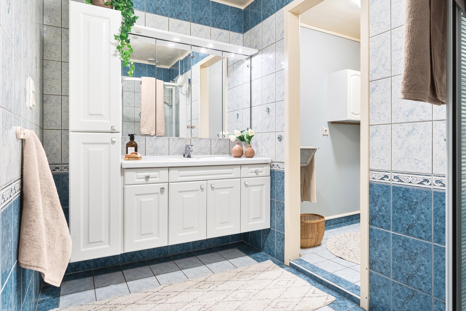 Helfliset bad innredet med baderomsinnredning med servant og dusjkabinett. Galleribilde