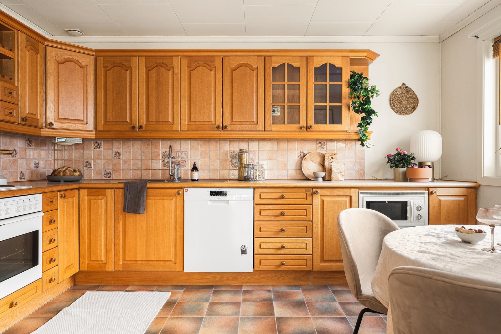 Kjøkkeninnredning fra Huseby med profilerte fronter i heltre og laminat benkeplate med nedfelt vask av stål Galleribilde