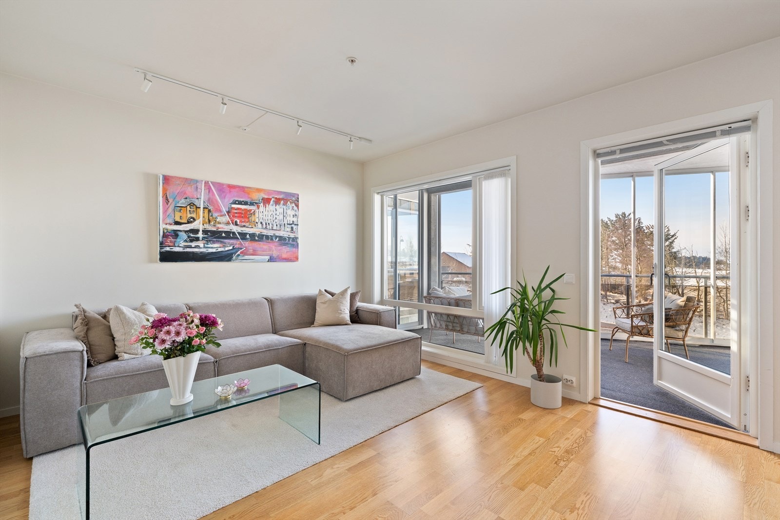 Innbydende stue med store vindusflater og direkte utgang til innglasset balkong. Galleribilde