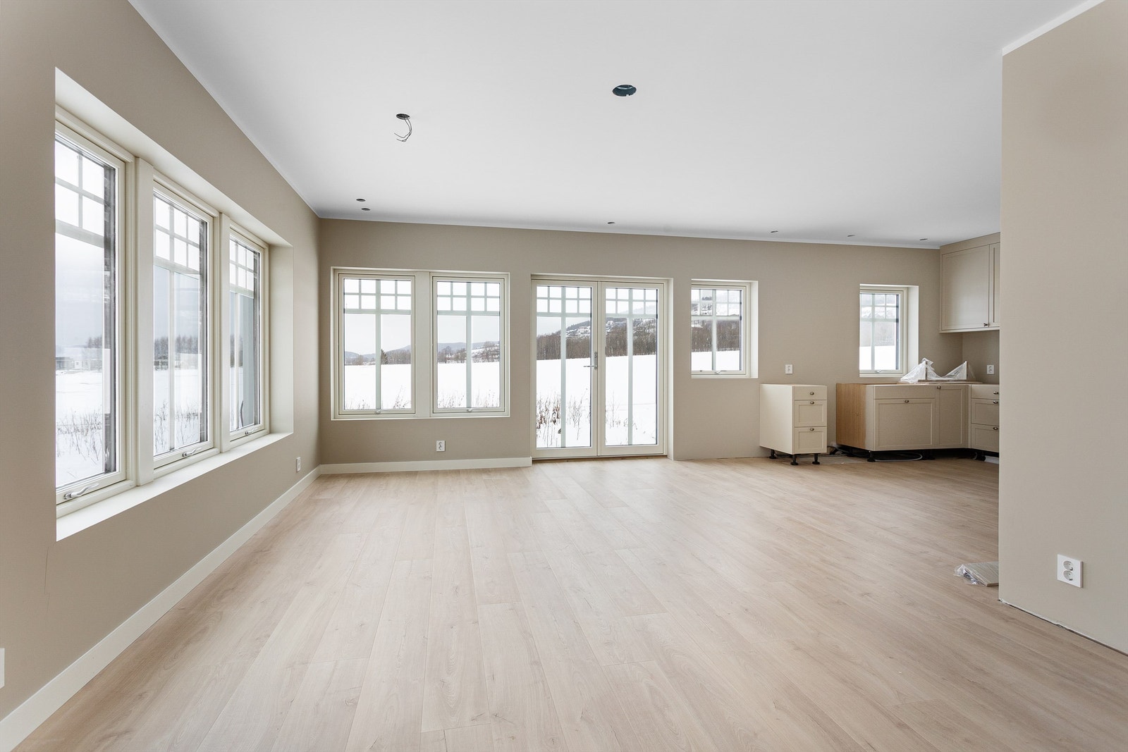 Første etasje har en åpen løsning mellom stue og kjøkken, med store vindusflater. Galleribilde