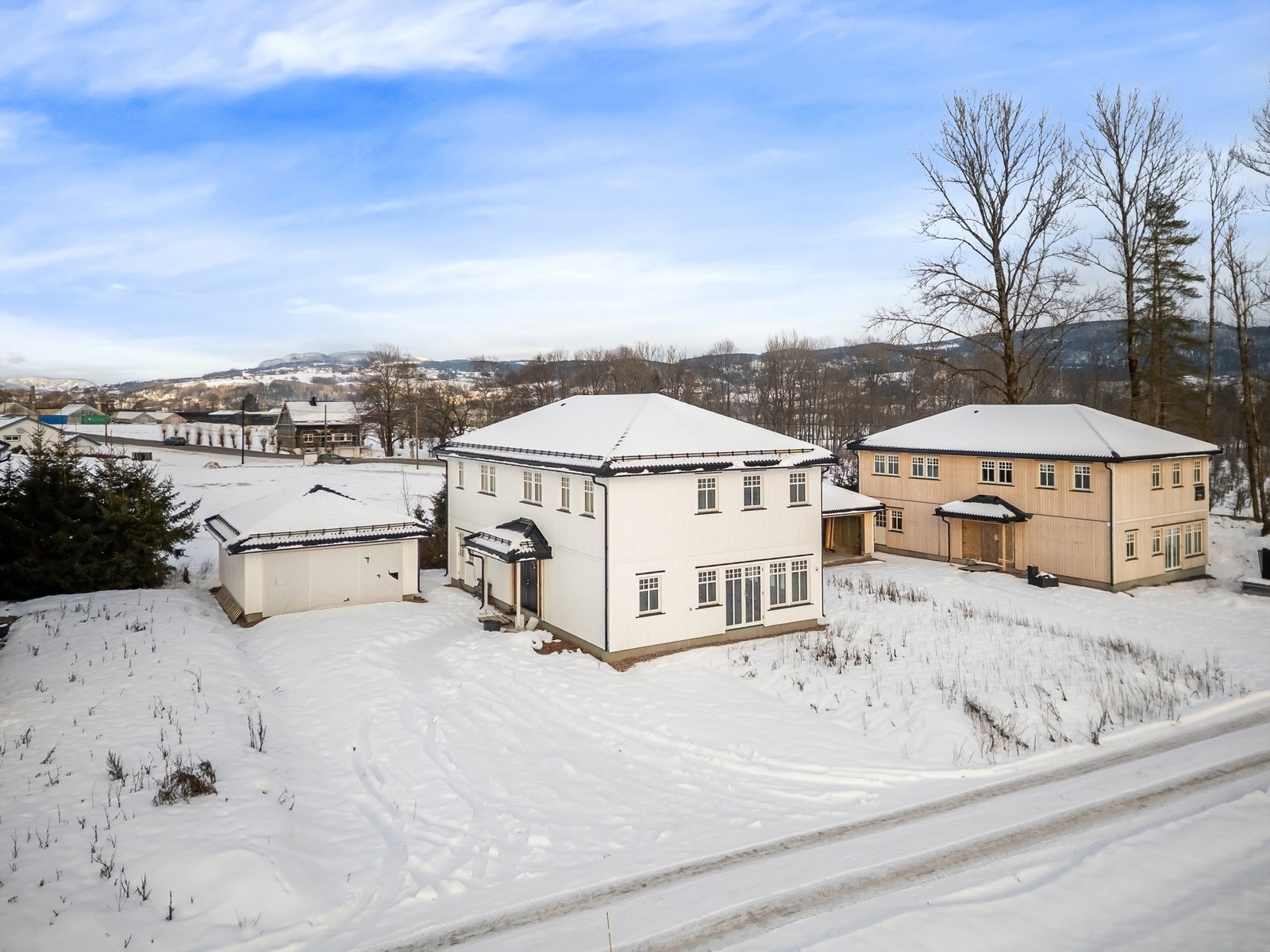 Flat tomt som er opparbeidet med grøntarealer og gruset gårdsplass. Galleribilde