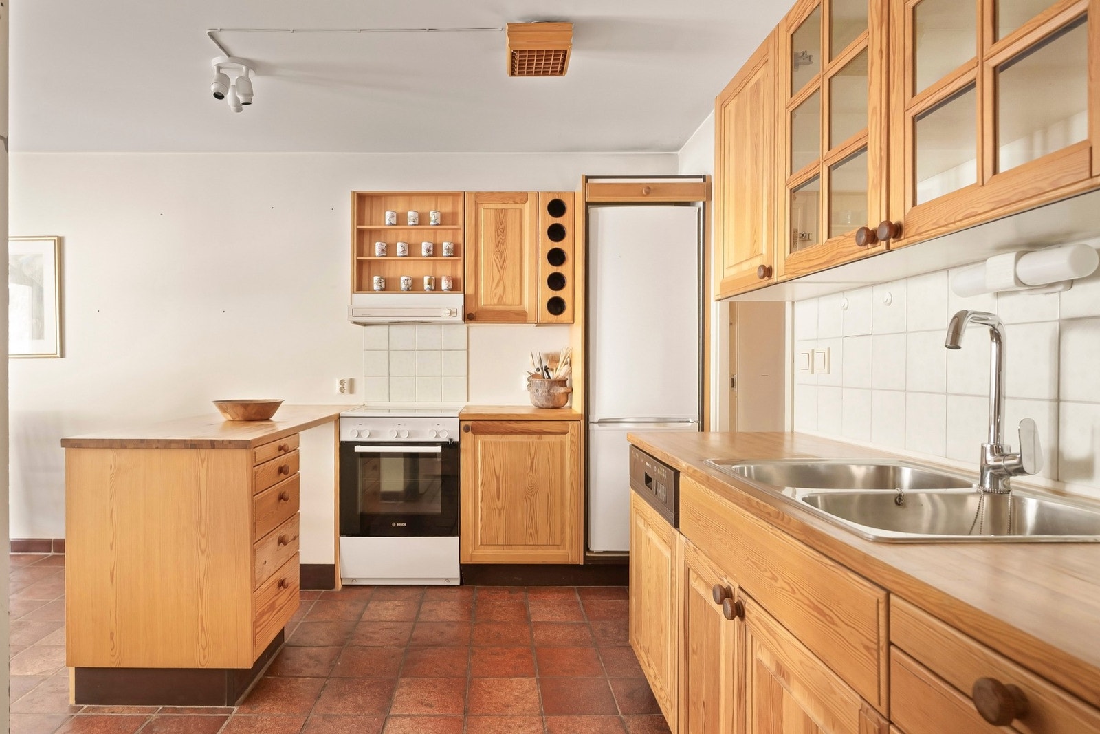 Det består av en halvøy, profilerte fronter, benkeplate av treverk og plass til frittsåtende komfyr og kjøleskap. Galleribilde