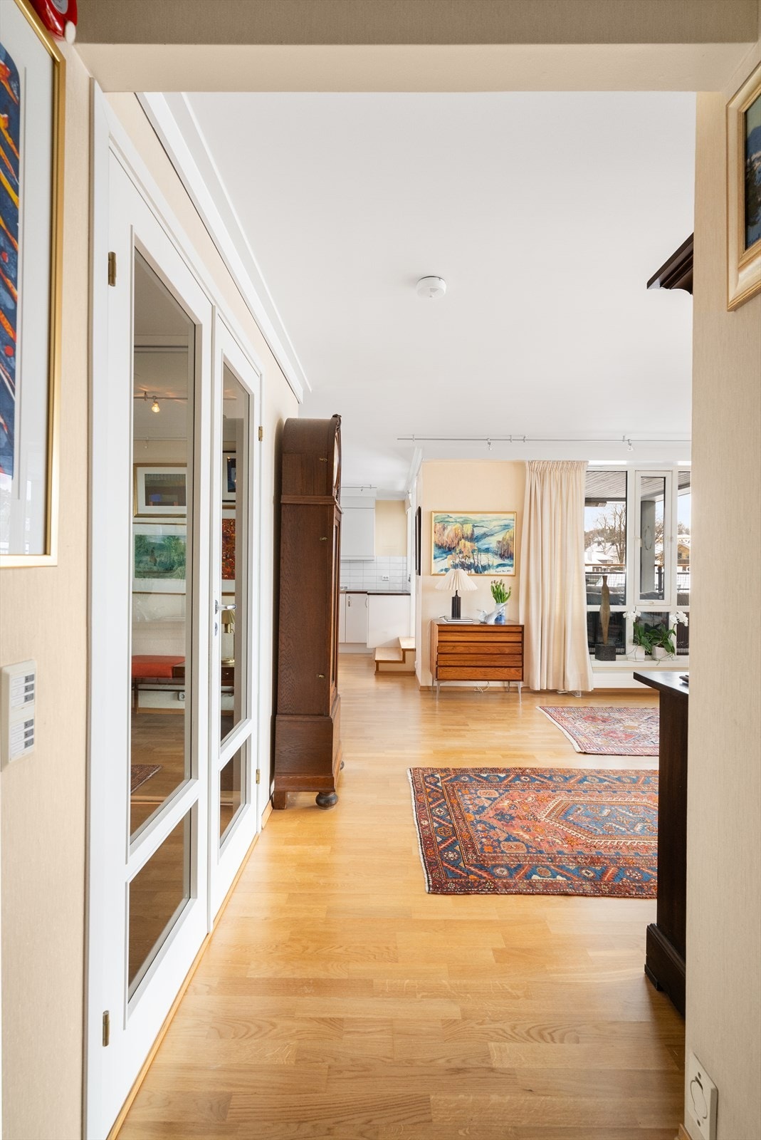 Selger opplyser at vegg mellom hall og stue, med dobbel glassdør, ble valgt som tilvalg for å skape en tydelig adskilt entré i leiligheten. Galleribilde