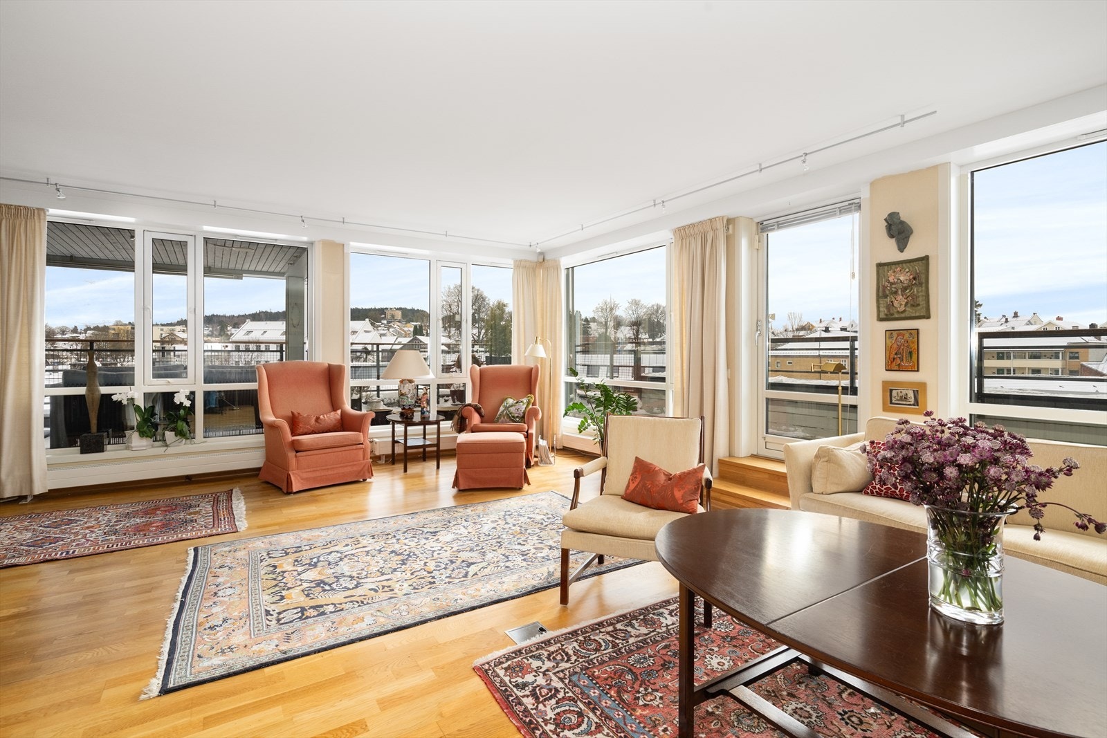 Stuen har store vinduer som nærmest strekker seg fra gulv til tak, hvor vindusflatene slipper inn rikelig med naturlig lys og skaper en luftig romfølelse. Galleribilde