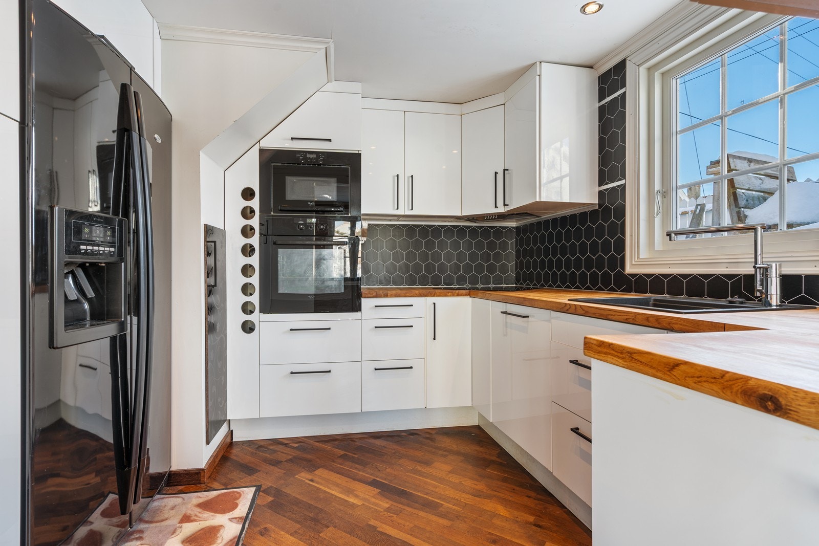 Utsnitt kjøkken m/side by side kjøl/frys og integrerte hvitevarer og vinhylle Galleribilde