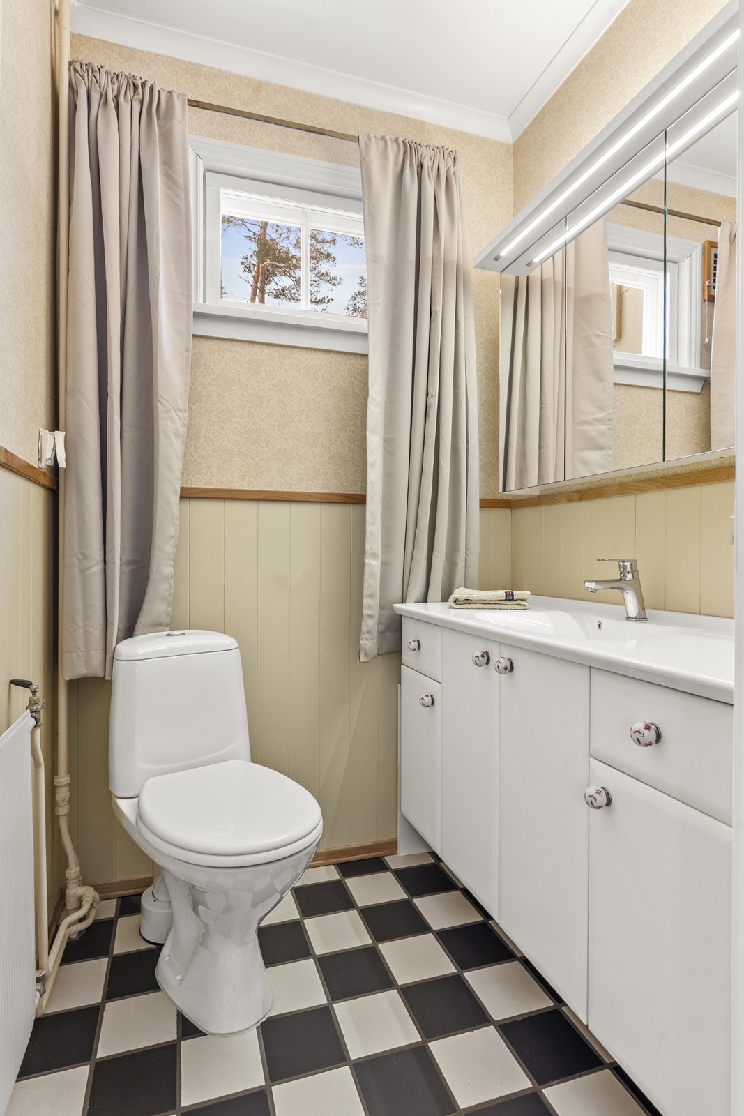 Praktisk toalettrom i første etasje med flislagt gulv, servant og WC. Galleribilde