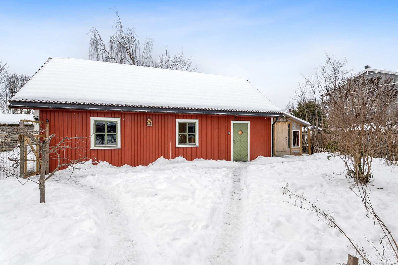 Dobbelgarasje i fin stil som sammen med de andre byggene danner et pent tun. Galleribilde