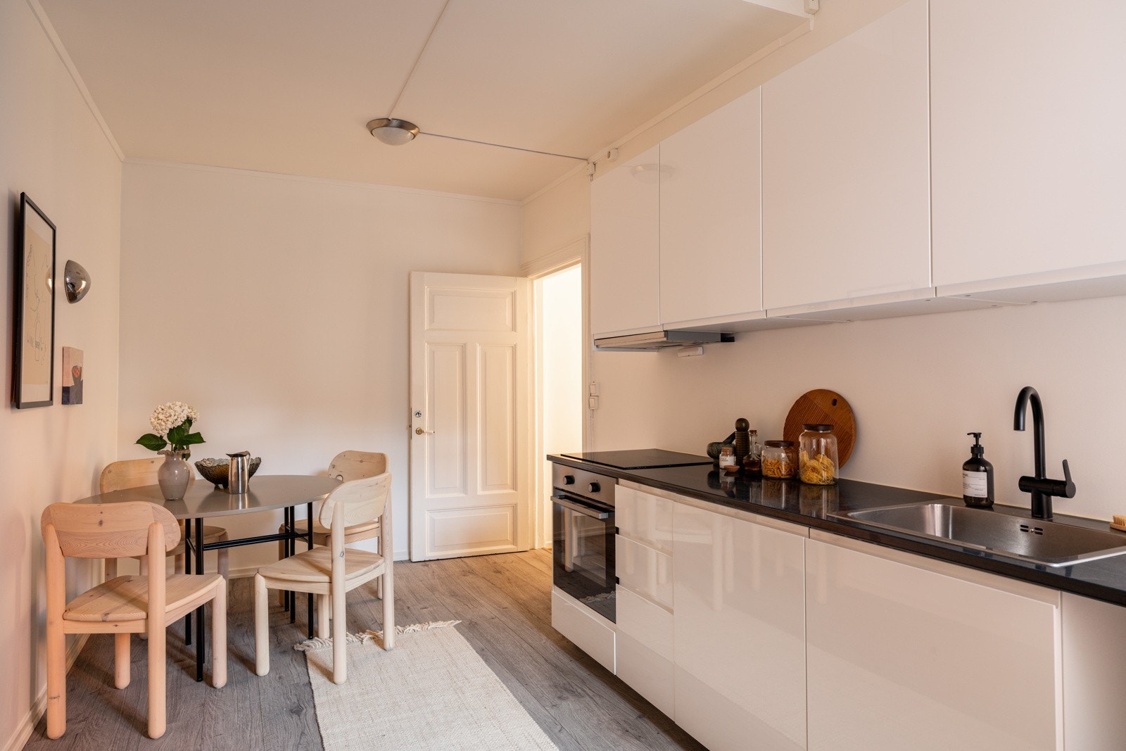 Moderne kjøkkeninnredning med hvite glatte fronter og laminert benkeplate med nedfelt oppvaskkum. Galleribilde