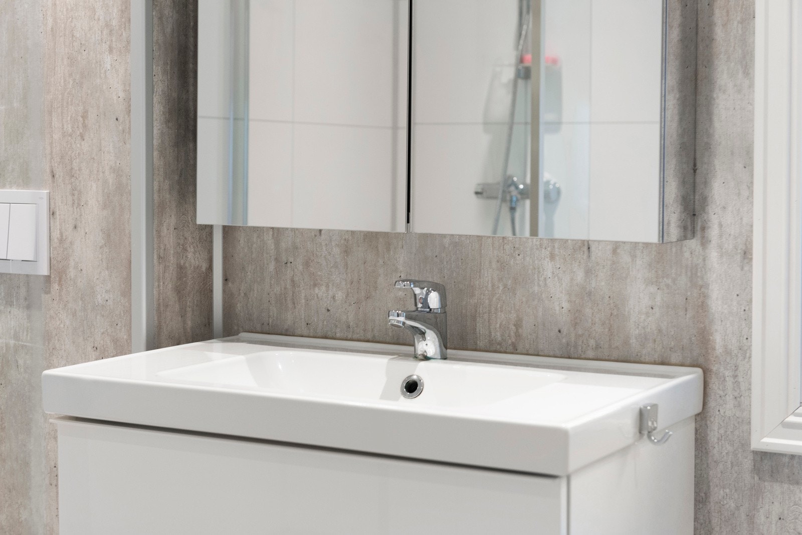 A utstyr finnes dusjhjørne, vegghengt klosett, servant med skuffer og speilskap. Galleribilde