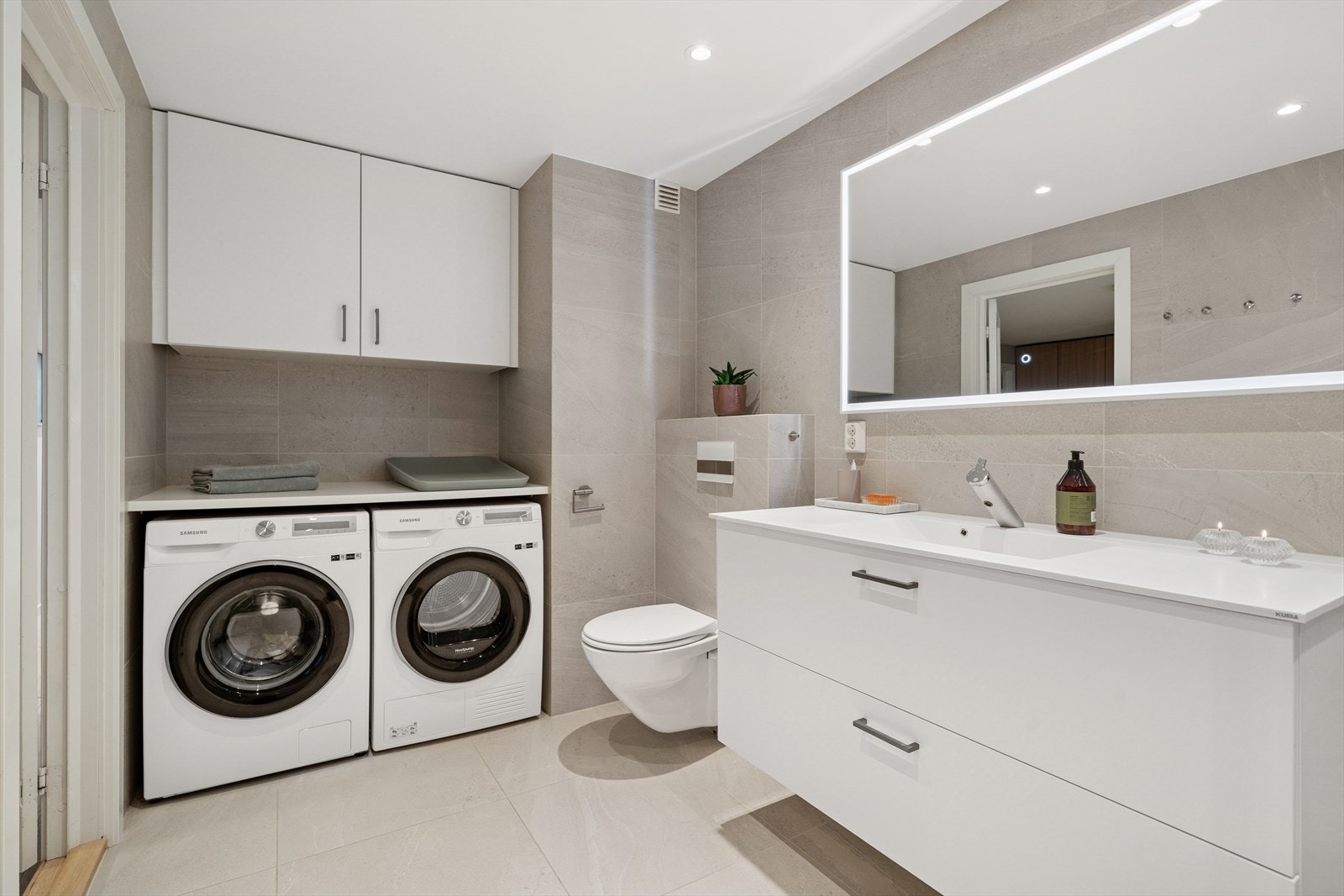 Lekkert og stort flislagt bad med opplegg til vaskemaskin og tørketrommel. Galleribilde